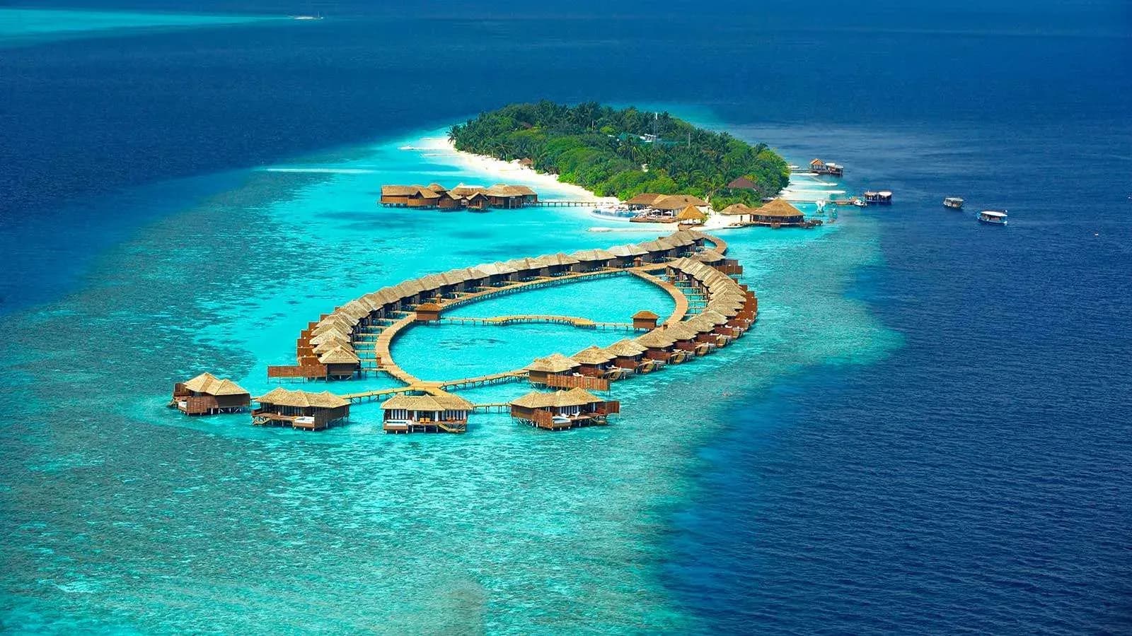 Aerial view of Lily Beach Resort & Spa's overwater villa loop and reef-ringed lagoon, Huvahendhoo, South Ari Atoll