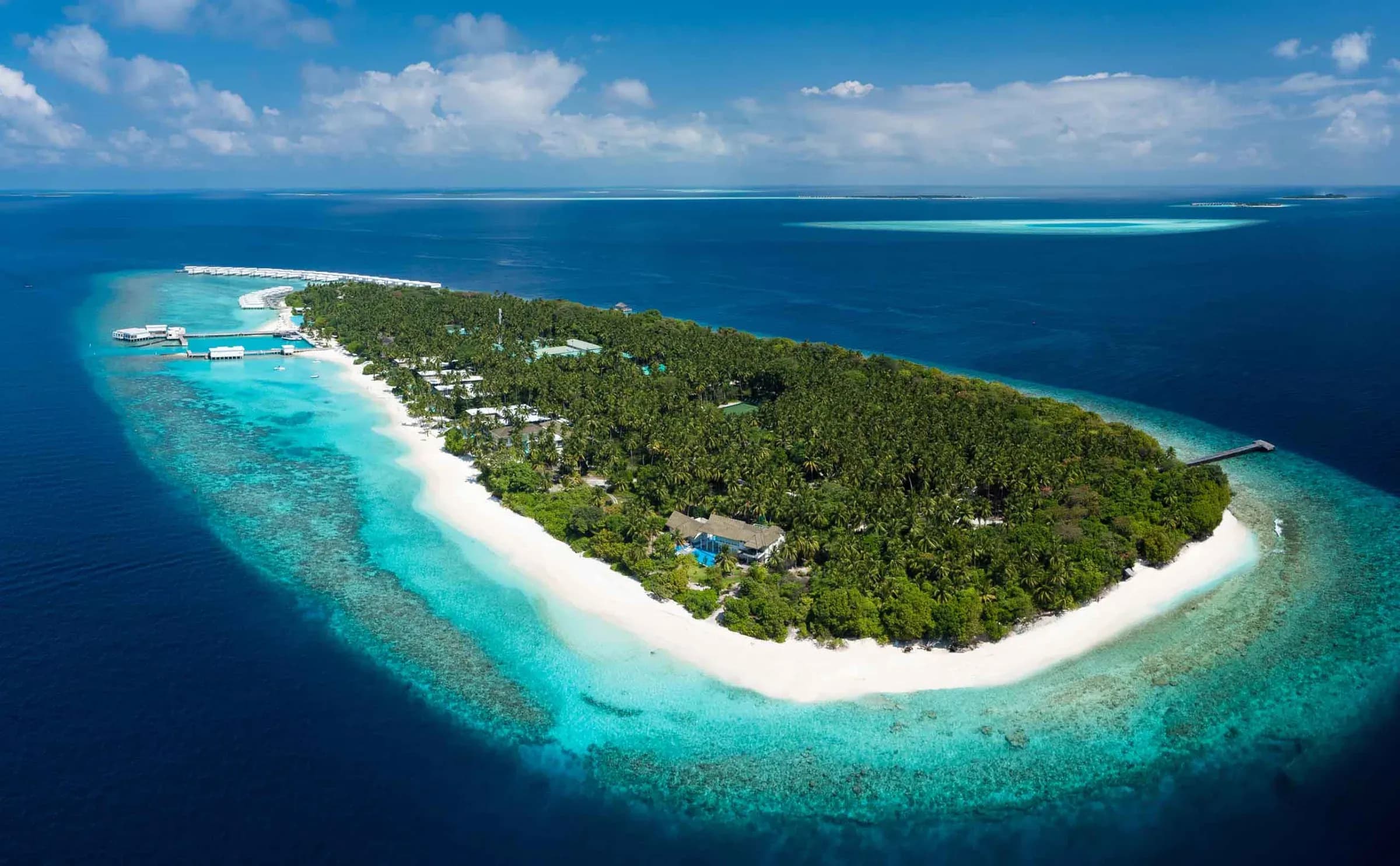 Aerial view of Amilla Maldives' reef, beach and overwater villas, Baa Atoll