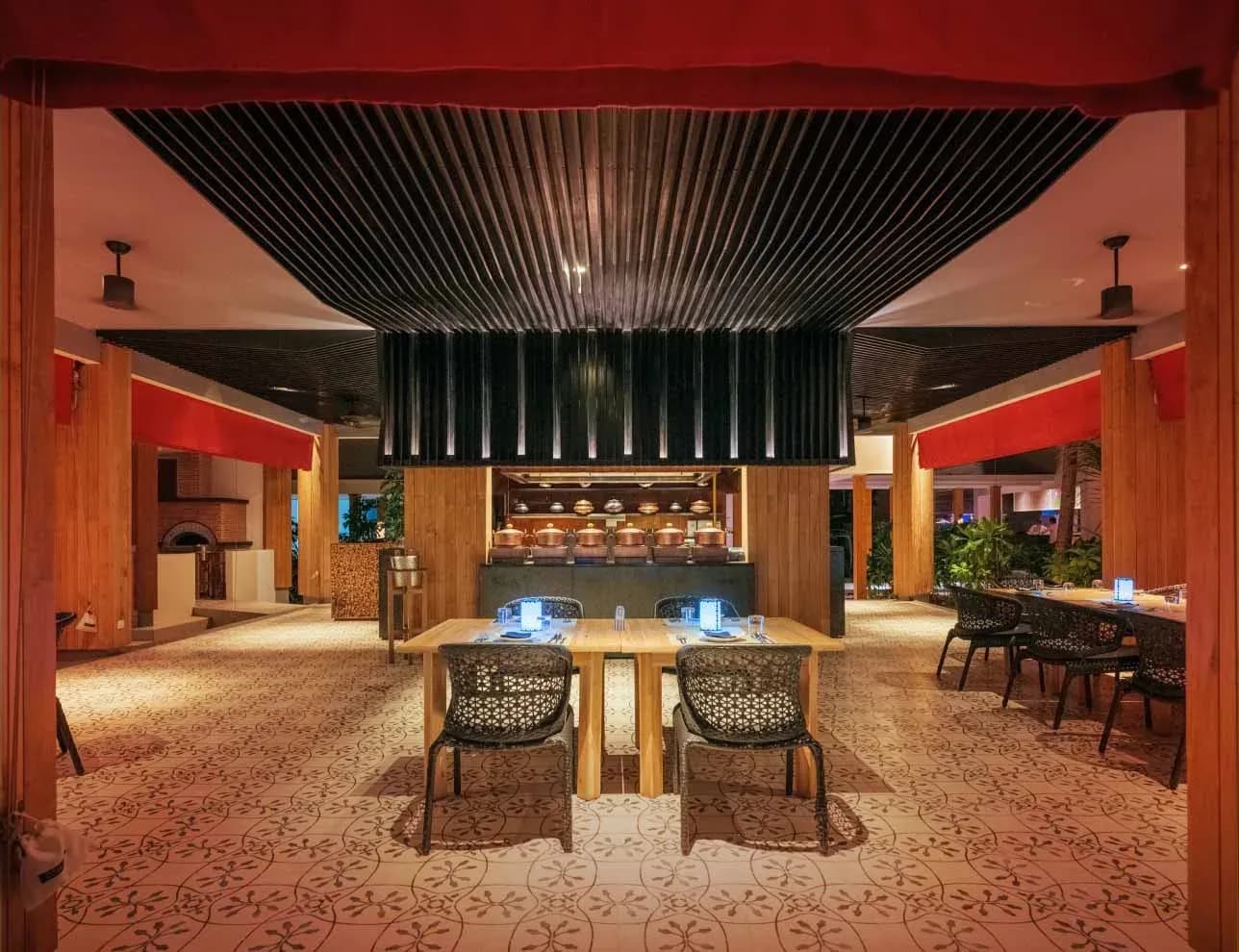 EAST restaurant interior with open kitchen at Amilla Maldives