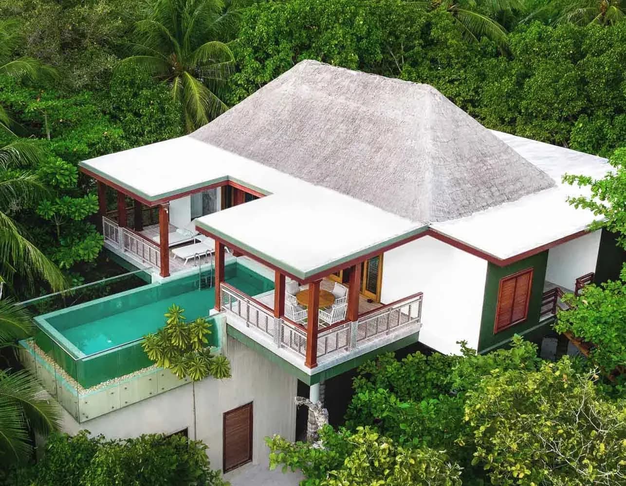 Aerial view of a Two-Bedroom Treetop Pool Villa amid the jungle canopy at Amilla Maldives