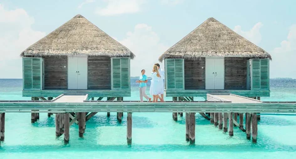 Guest walking through the overwater Anantara Spa at Anantara Kihavah Maldives Villas