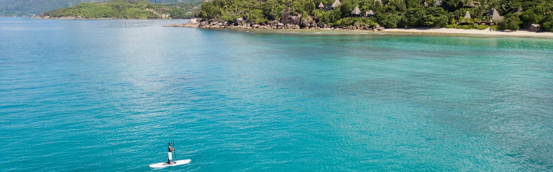 Stand-up paddleboarding off the beach at Anantara Maia Seychelles Villas