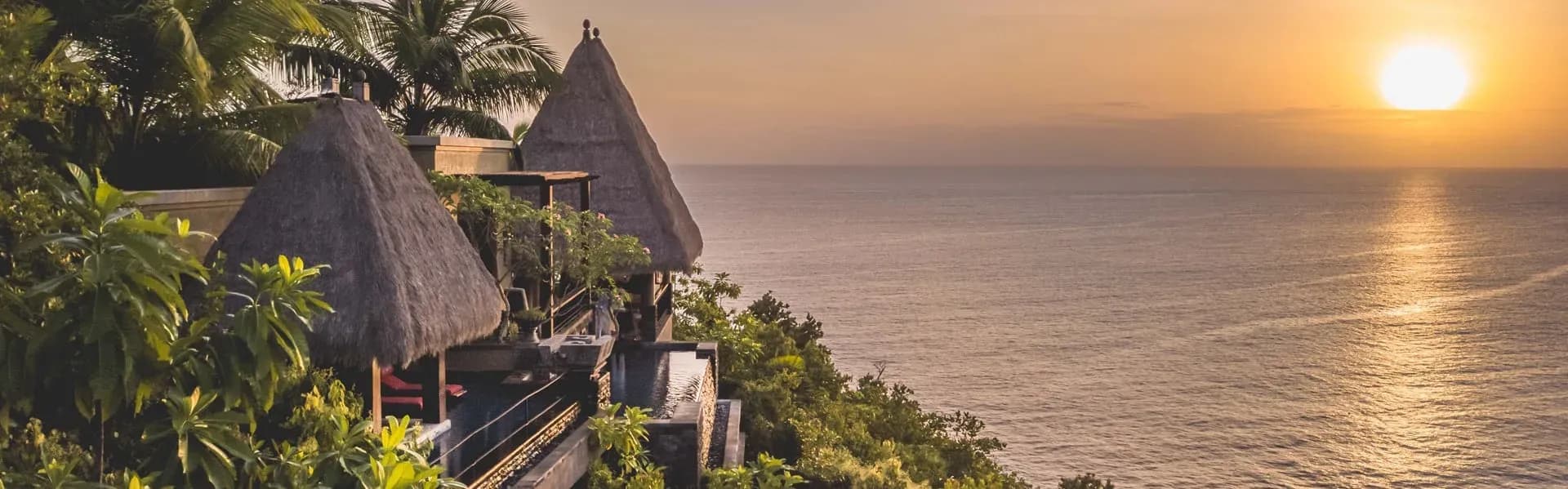 Aerial sunset view over private pool villas and forested hillside at Anantara Maia Seychelles Villas, Mahe