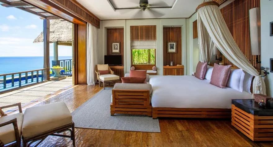 Peninsula Ocean View Pool Villa bedroom with panoramic ocean views at Anantara Maia Seychelles Villas