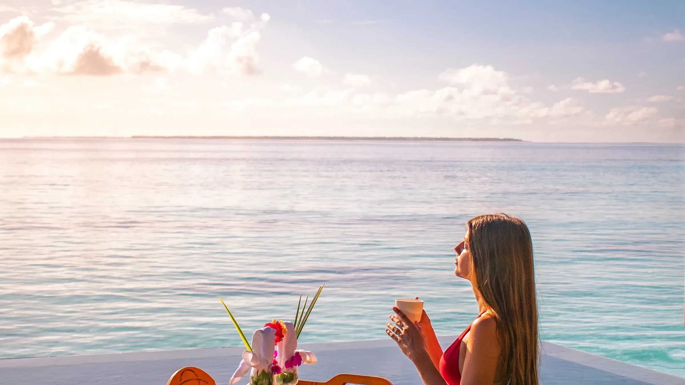 Sunset over the lagoon at Ayada Maldives, seen from an overwater pool deck