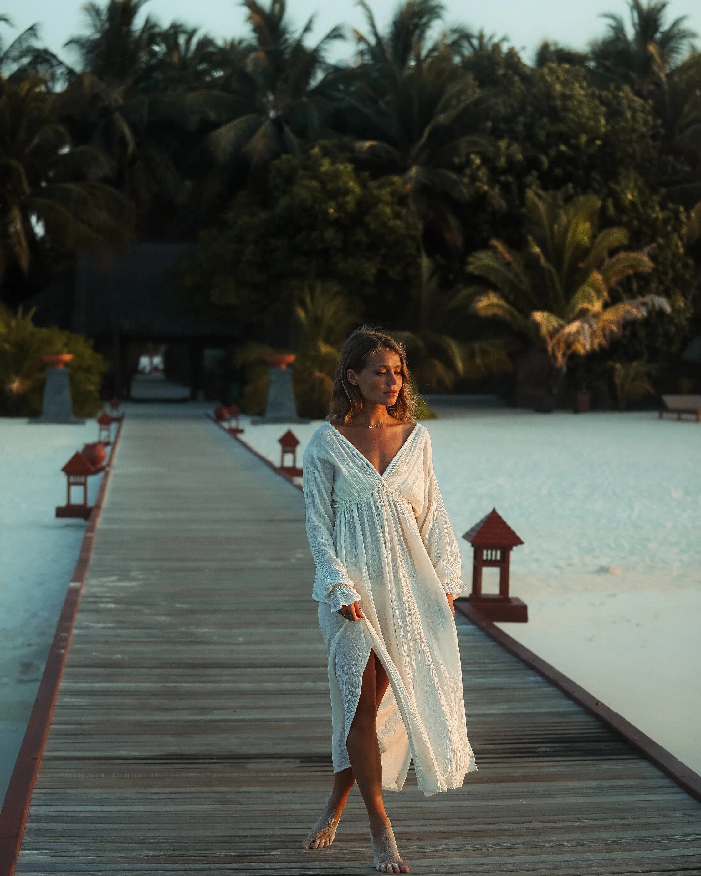 Wooden jetty leading to Banyan Tree Vabbinfaru's beach villas over clear water