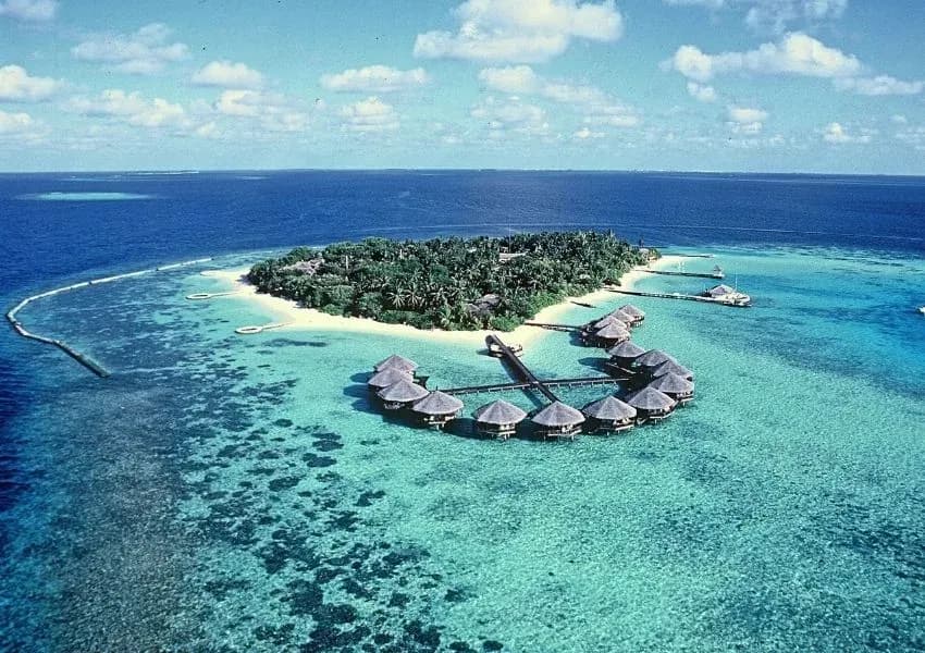 Aerial view of Baros Maldives island with overwater villas fanning out into the reef, North Malé Atoll