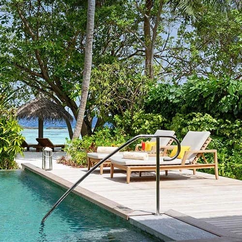 Private pool deck of the Baros Residence set among tropical gardens