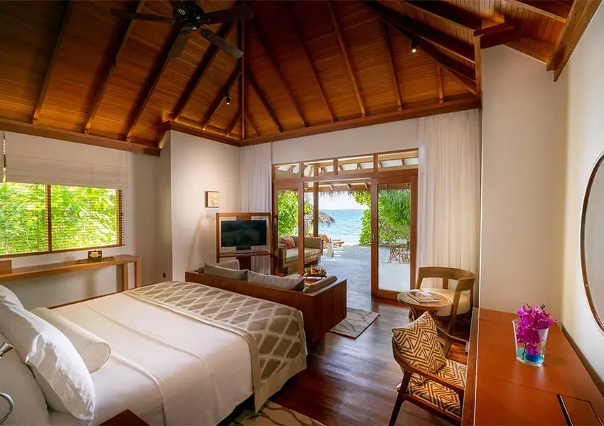Bedroom interior of a Deluxe Beach Villa at Baros Maldives