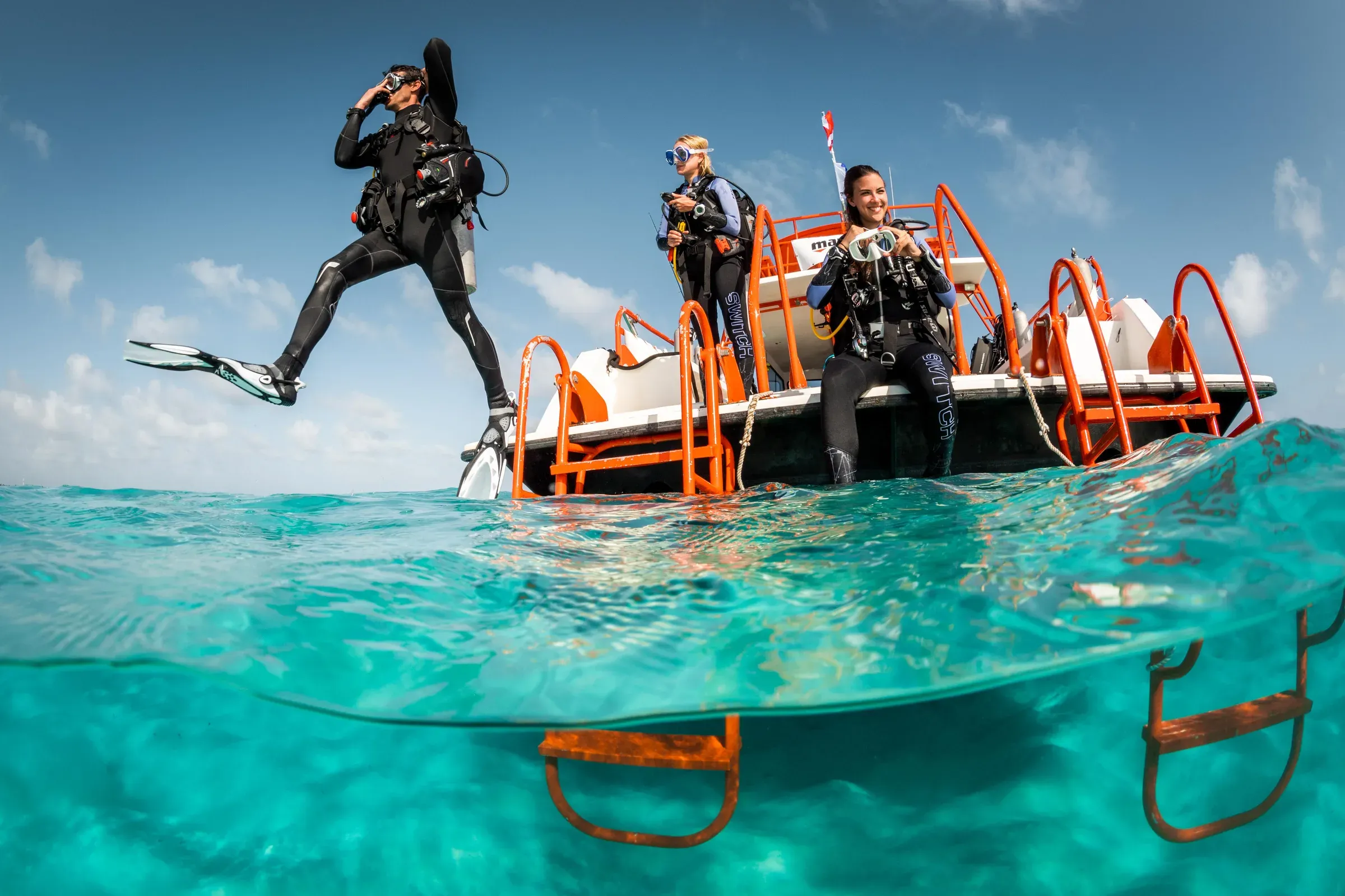Divers preparing to enter the water from the dive boat at Bawe Island