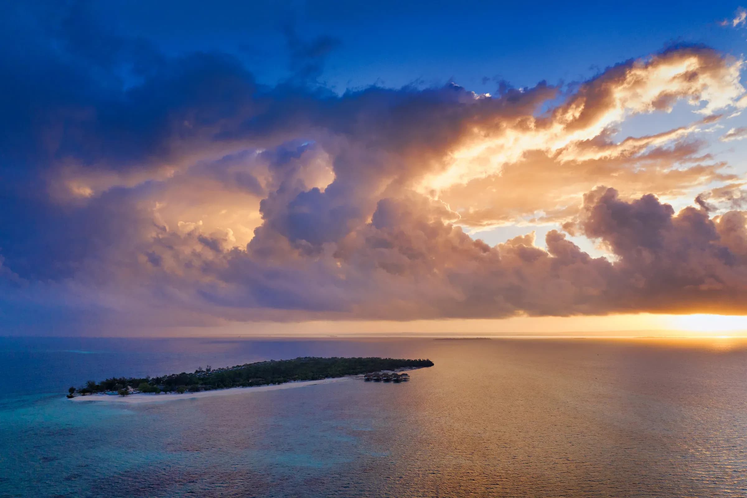 Dramatic sunset aerial over Bawe Island, a private island resort off Stone Town, Zanzibar