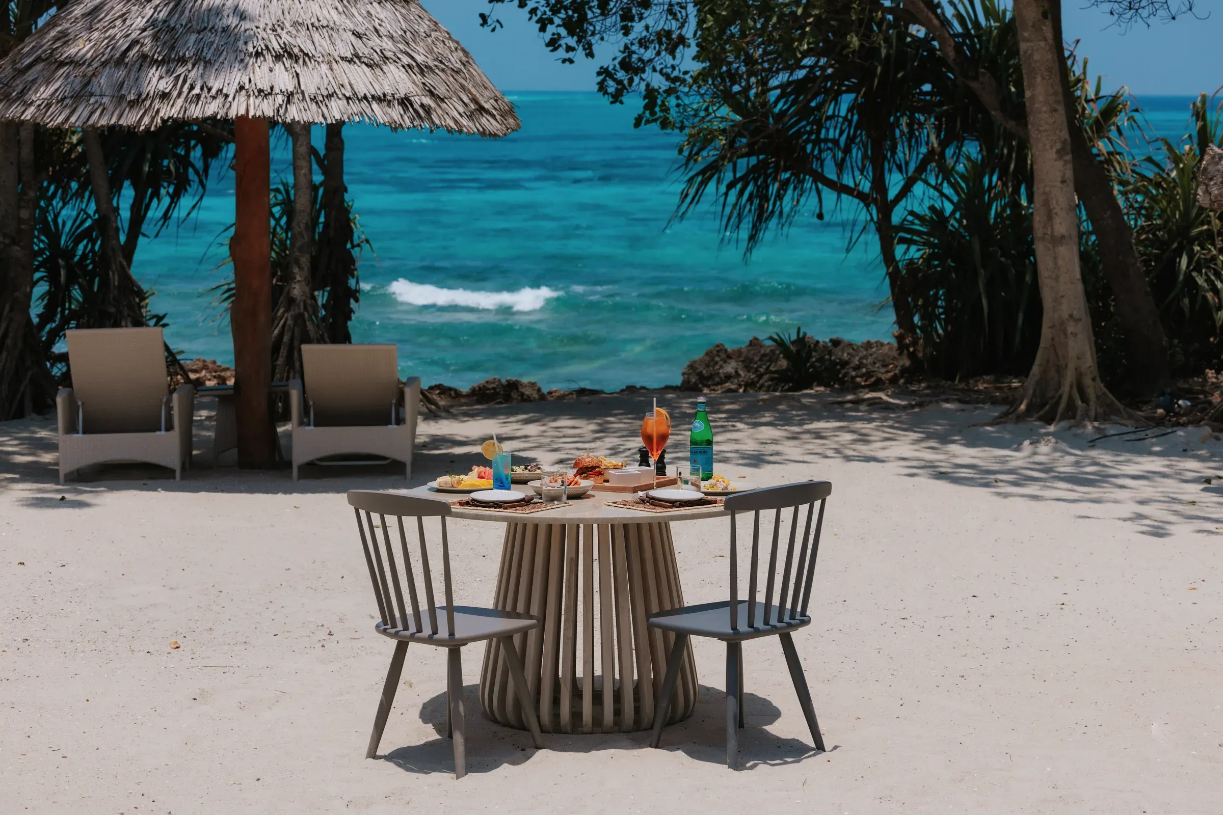 Beachfront table set for dining at The Beach Club, Bawe Island