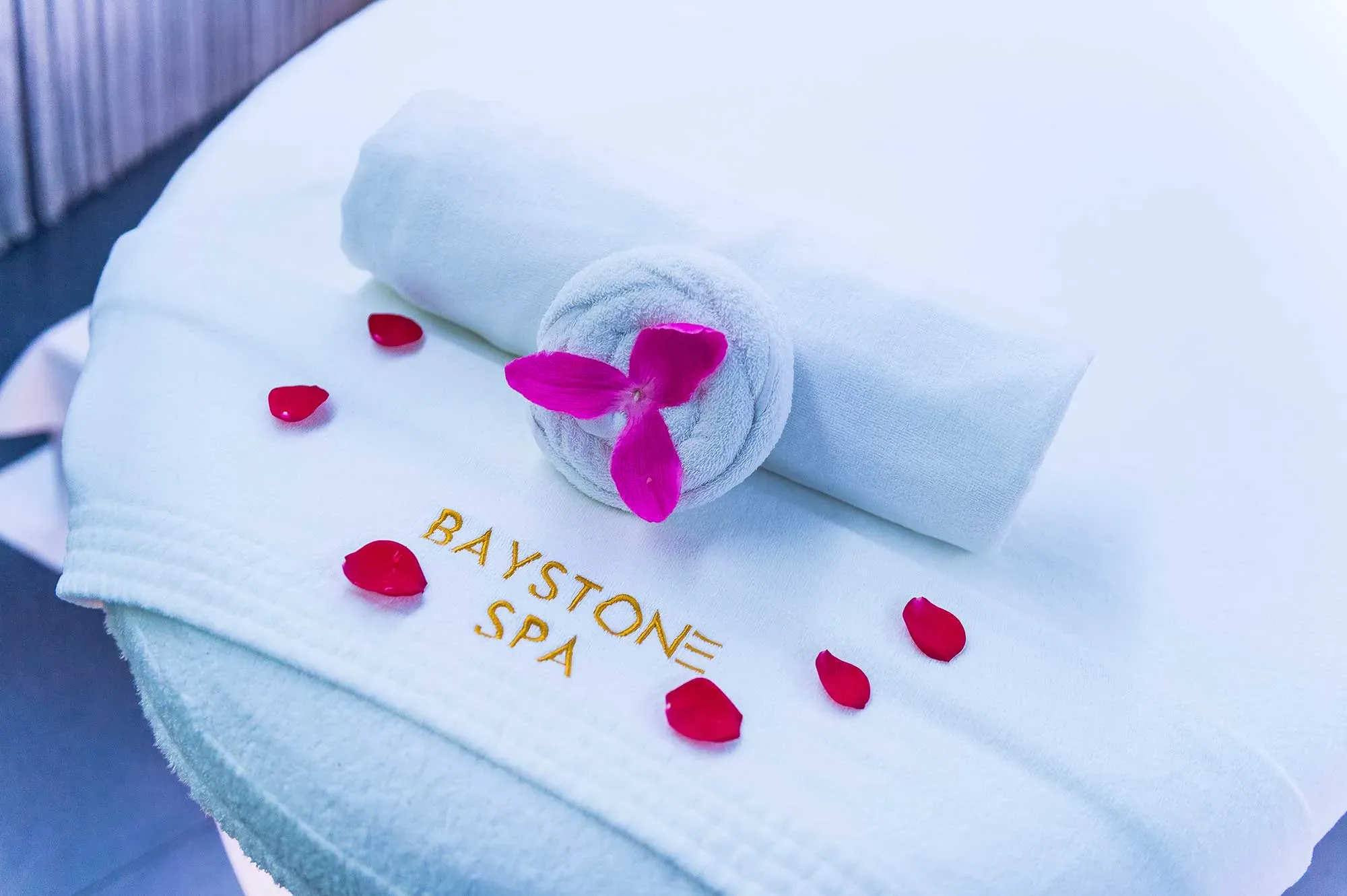 Baystone Spa treatment table with rolled towels and petals