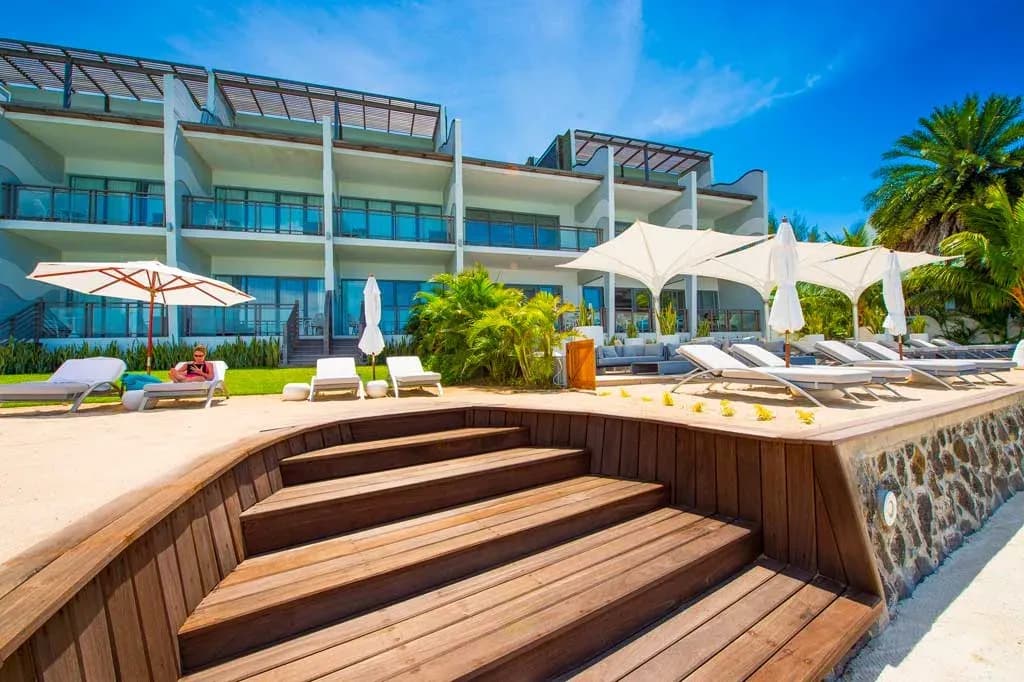 Sunset view of Baystone Boutique Hotel & Spa's beachfront terrace and sun loungers, Pointe aux Canonniers, Mauritius