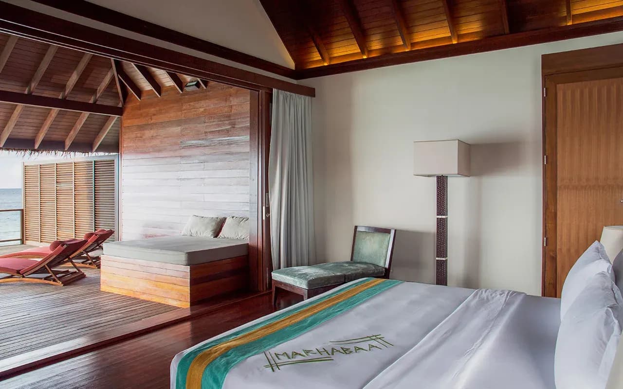 Water Villa with Pool interior and infinity pool over the lagoon at Coco Bodu Hithi