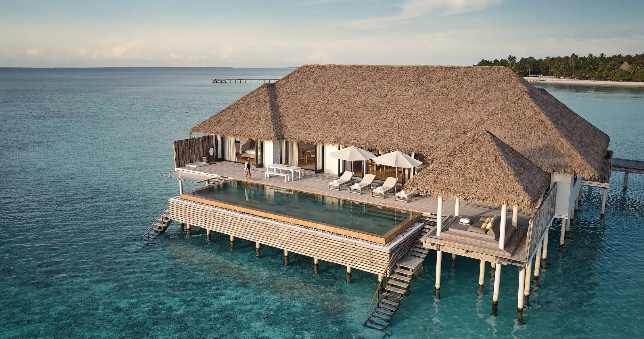 Aerial view of a COMO Maalifushi water villa with private pool and beach beyond
