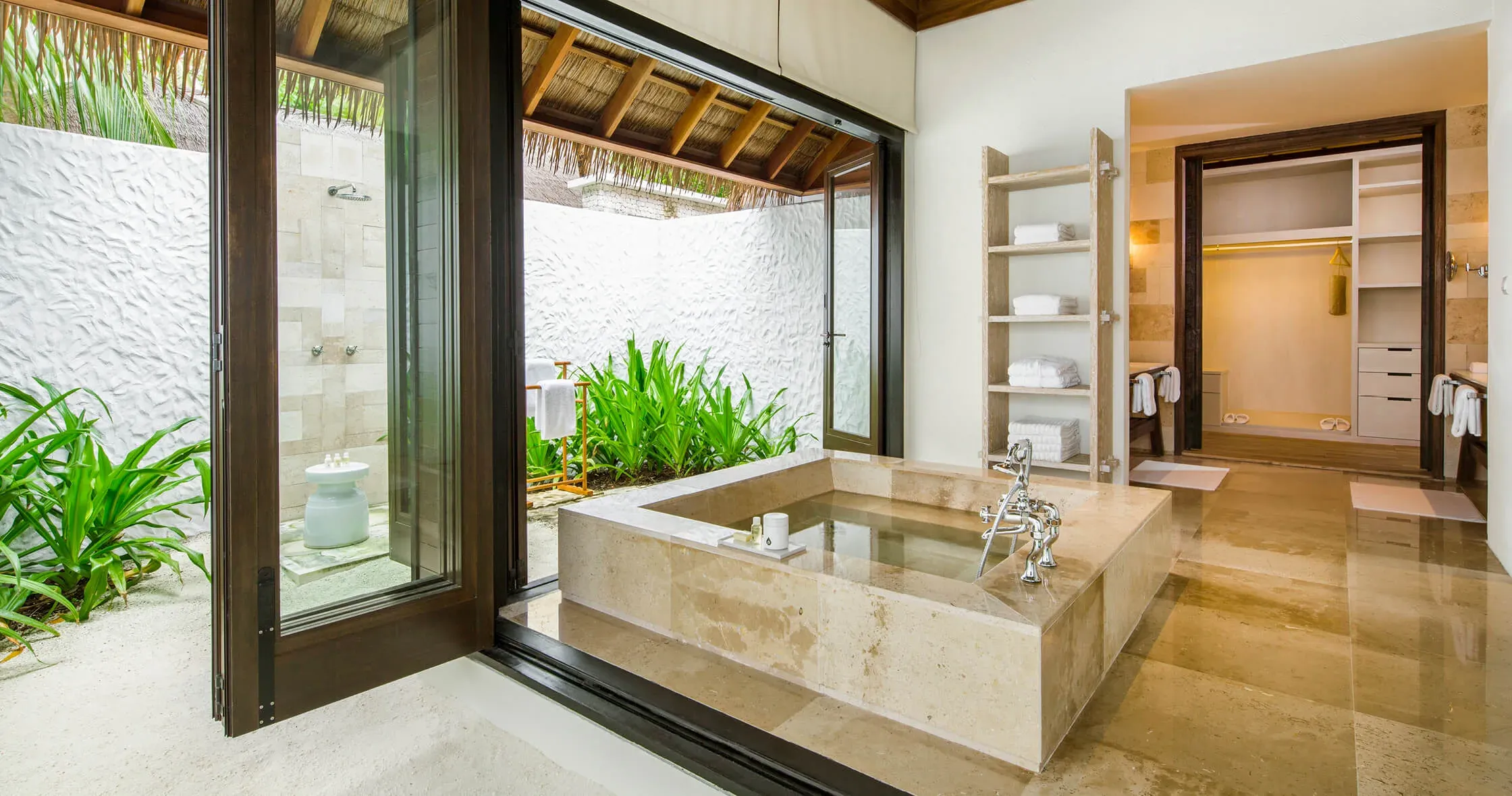 Water Villa deck with sunken lounge seating and glass floor over the lagoon at COMO Maalifushi