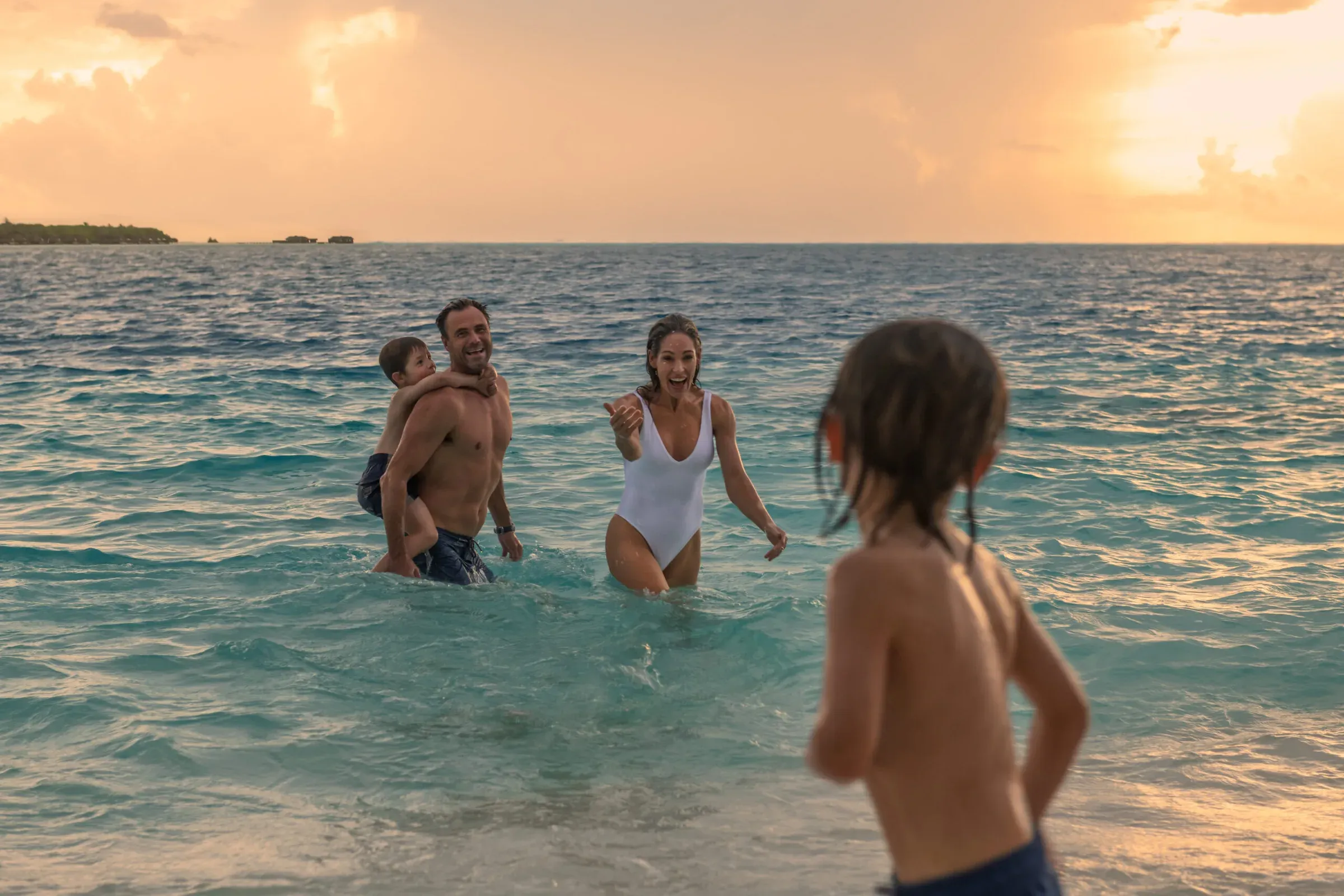 Family playing on the beach at sunset, Conrad Maldives Rangali Island