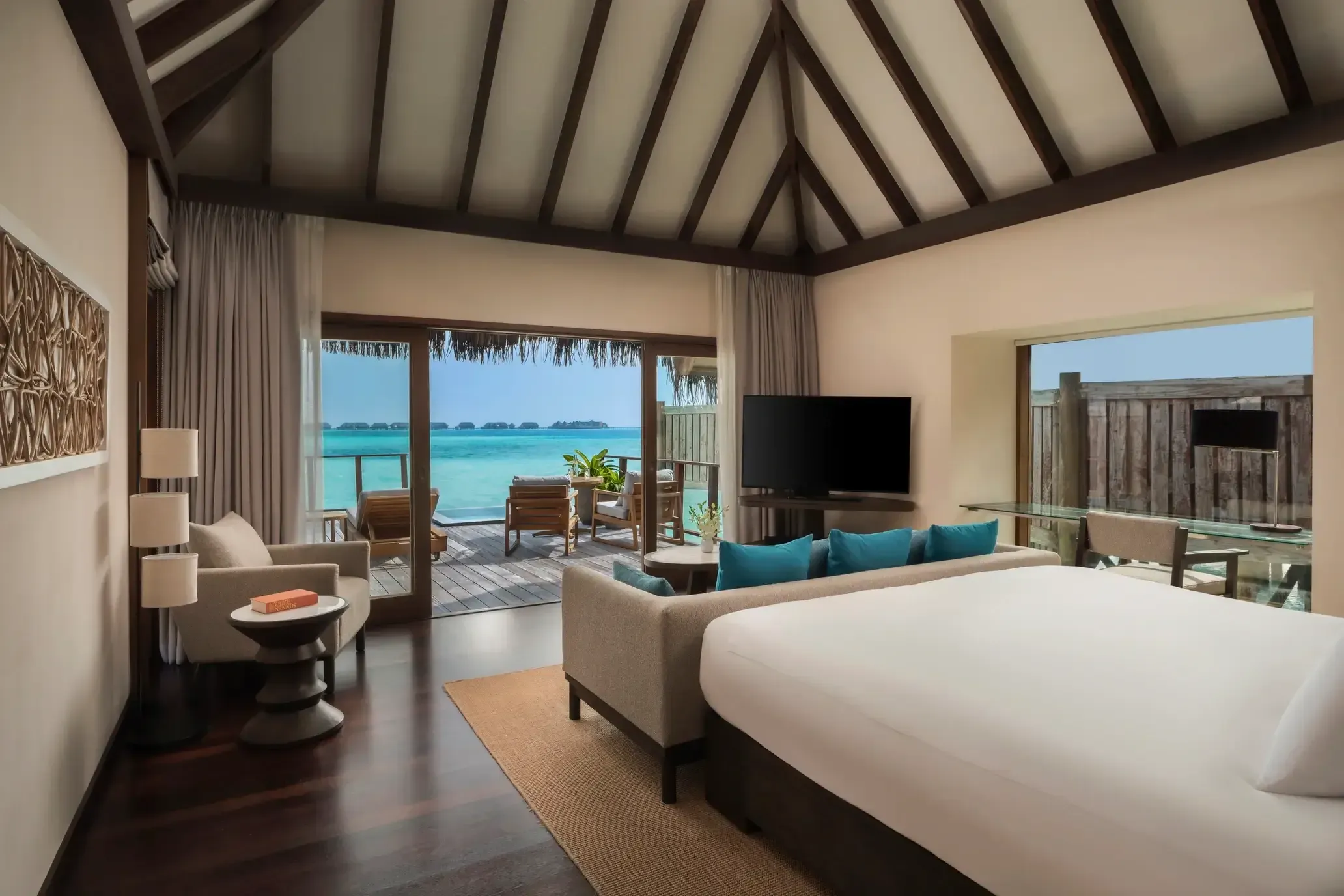 Bedroom of the Sunrise Water Villa overlooking the lagoon at Conrad Maldives Rangali Island