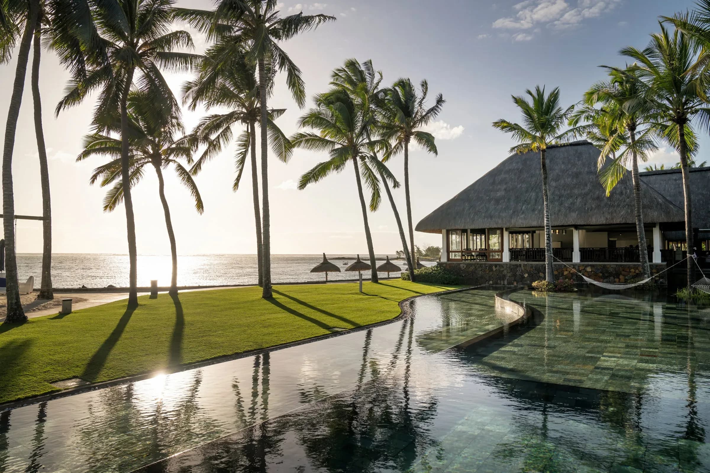 Infinity pool and beachfront terrace at sunset, Constance Belle Mare Plage