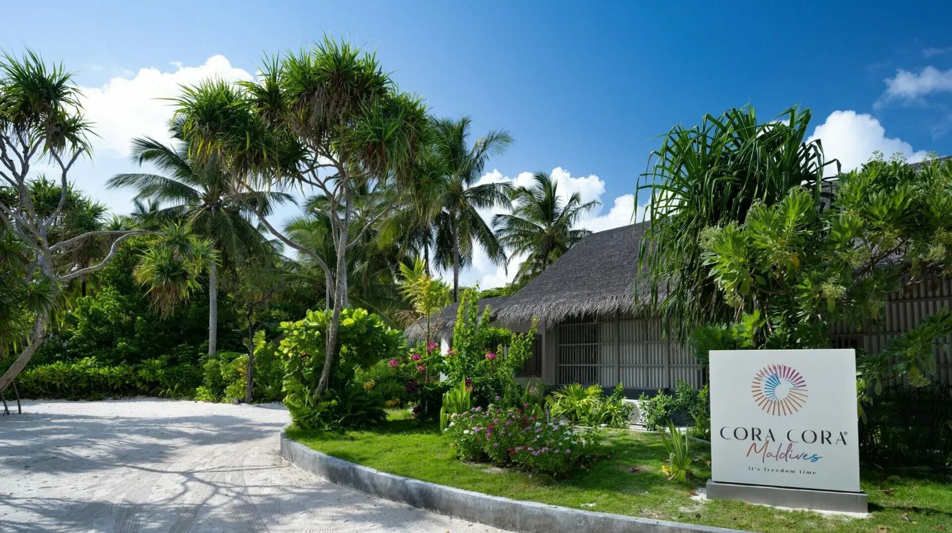 Cora Cora Maldives resort entrance sign framed by tropical gardens