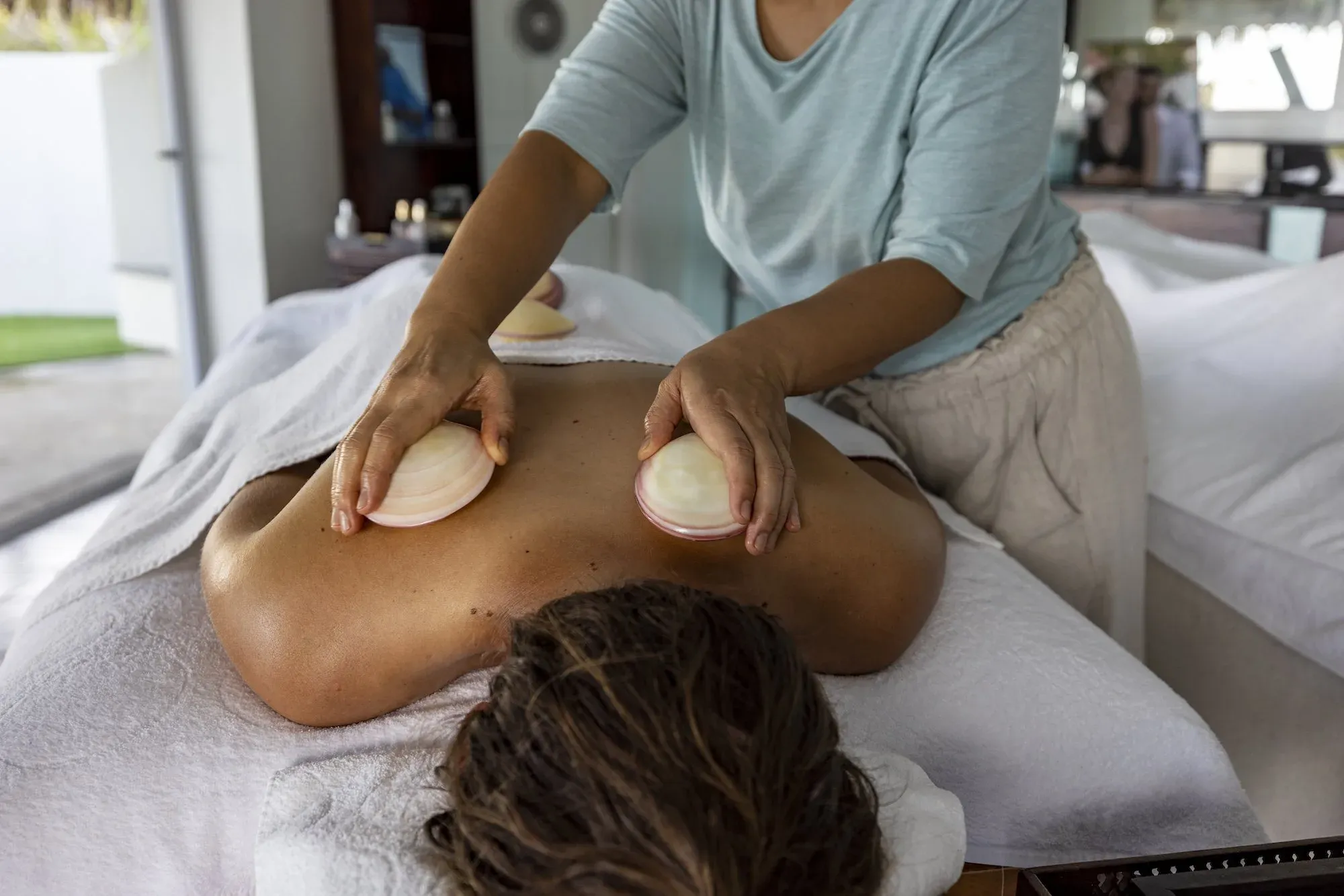 Massage treatment using warmed shells at the Lakaz Lo Lans Spa, Cousine Island