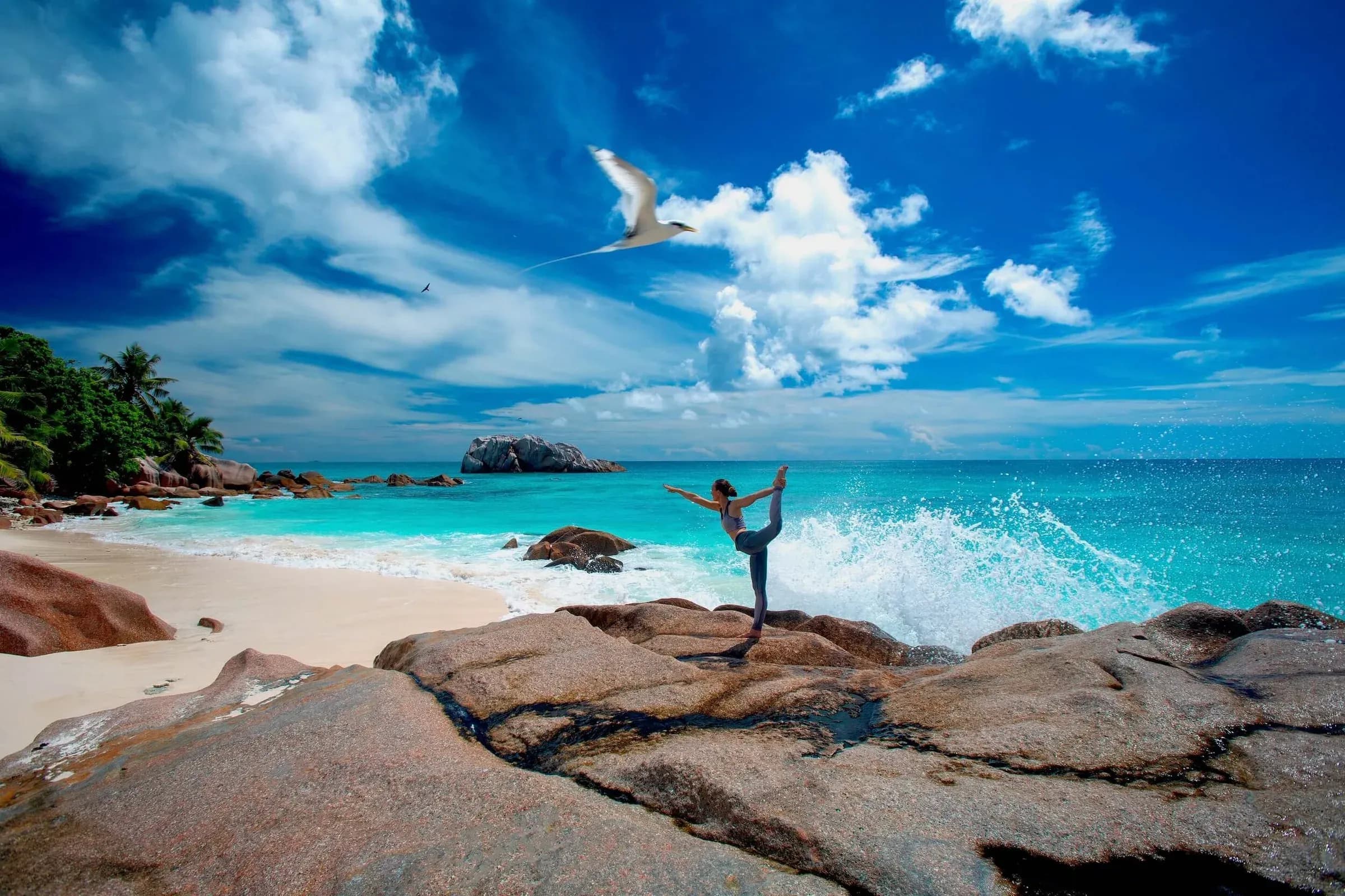 Yoga practice on the granite rocks above the surf at Cousine Island