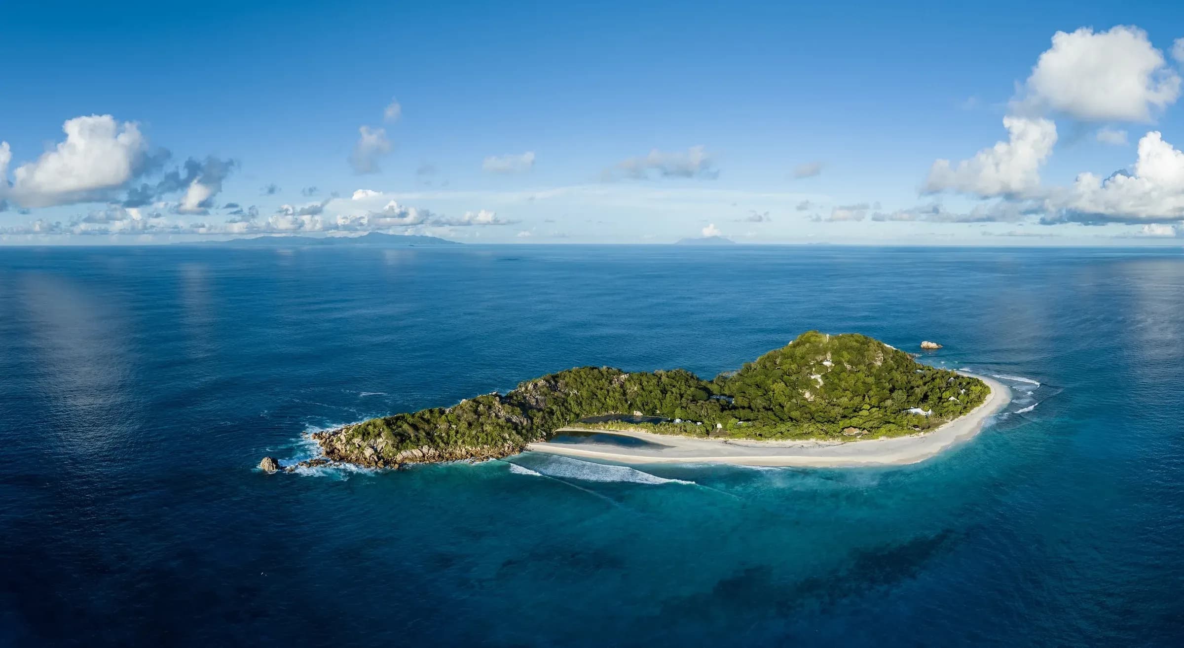Aerial view of Cousine Island, a private granite island fringed by white sand and turquoise reef, Seychelles