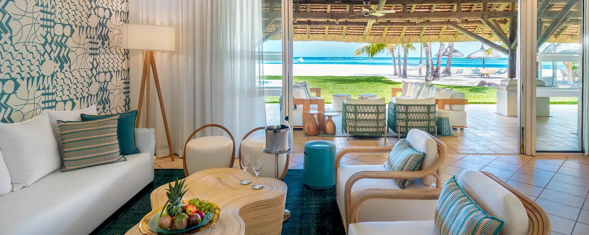 Dinarobin Villa terrace and lounge opening onto the beach, with palm-fringed lagoon views