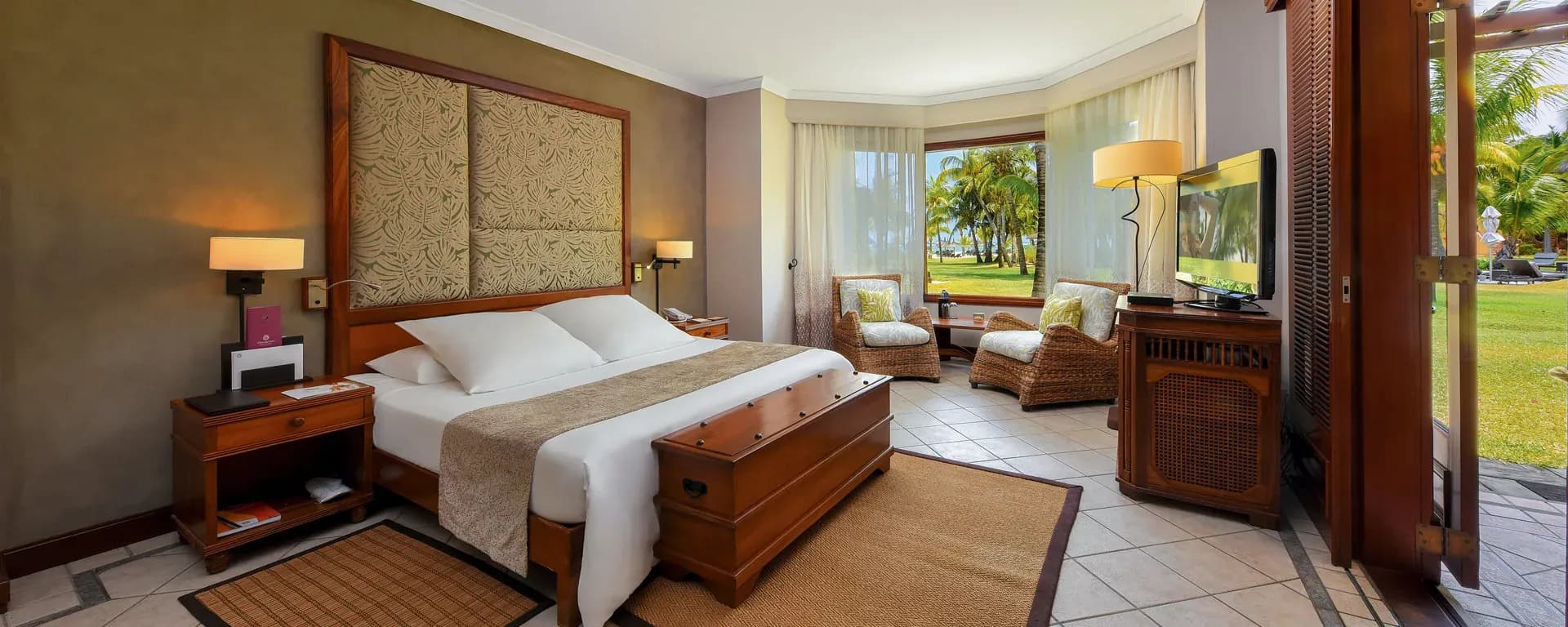 Ground-floor Junior Suite bedroom opening onto tropical gardens at Dinarobin Beachcomber
