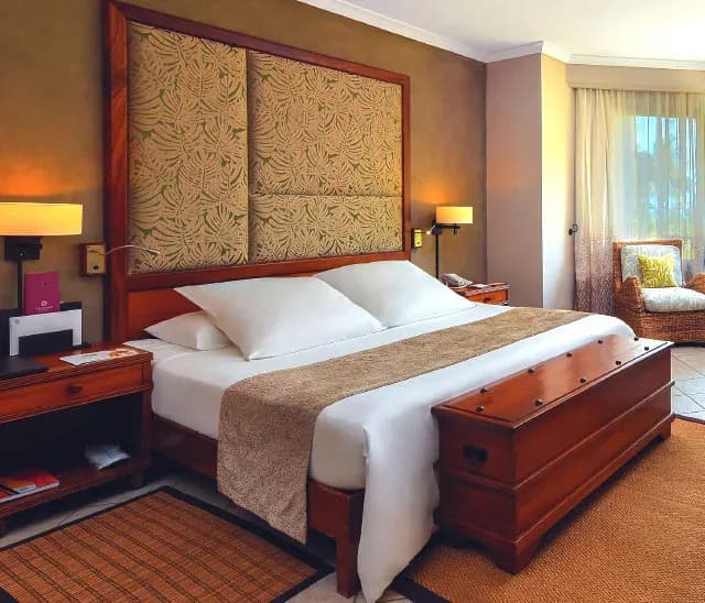 Junior Suite interior at Dinarobin Beachcomber, facing the sea with tropical garden views