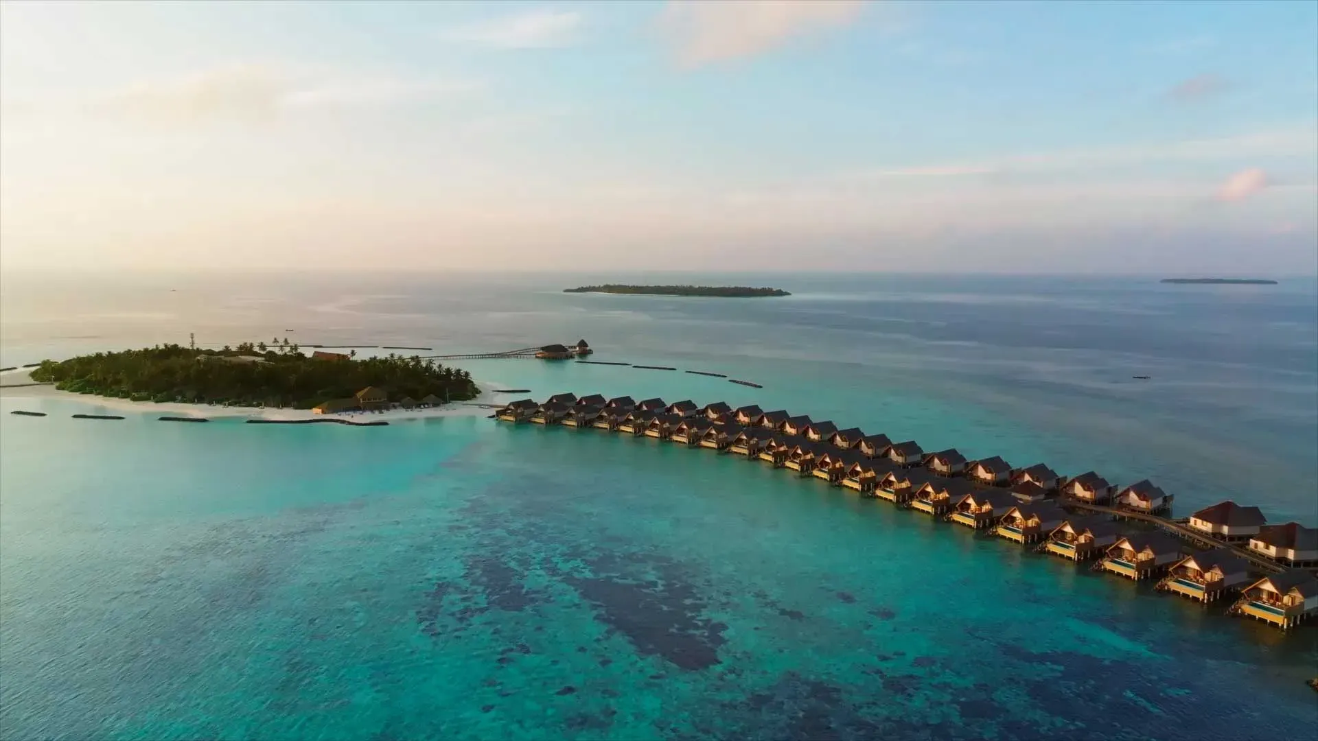 Aerial view of Emerald Faarufushi's overwater villa jetty and white-sand beach, Raa Atoll, Maldives