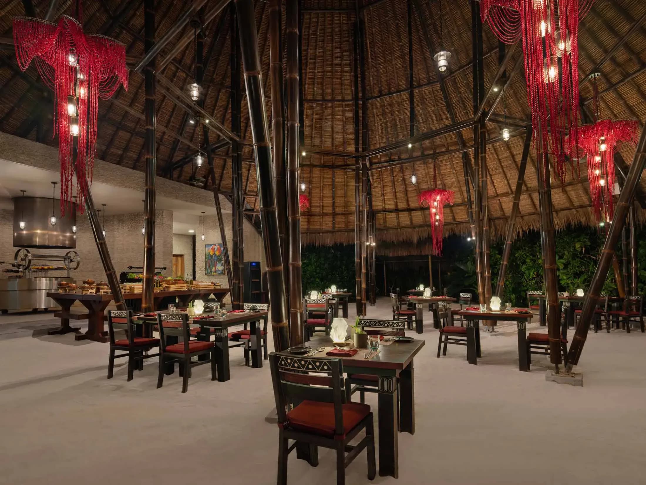Amazònico Restaurant's open kitchen and thatched dining room at Emerald Maldives Resort & Spa