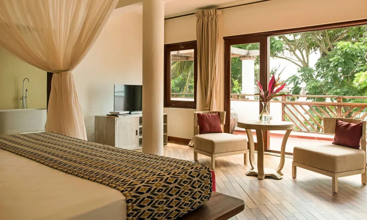 Partial Ocean View Villa bedroom and terrace among the treeline at Essque Zalu Zanzibar