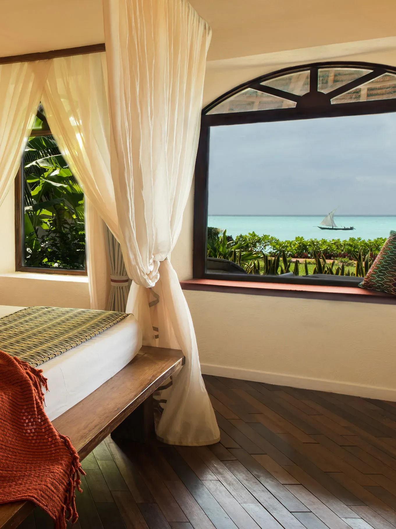 Seafront Suite window looking out over a passing dhow on the Indian Ocean at Essque Zalu Zanzibar