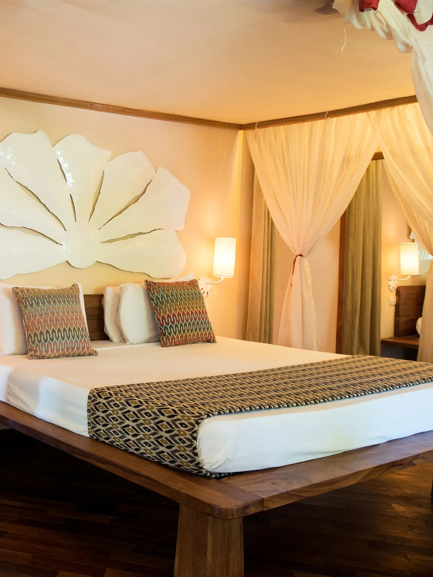 Capiz-shell headboard and canopy bed in a Superior Garden Suite at Essque Zalu Zanzibar