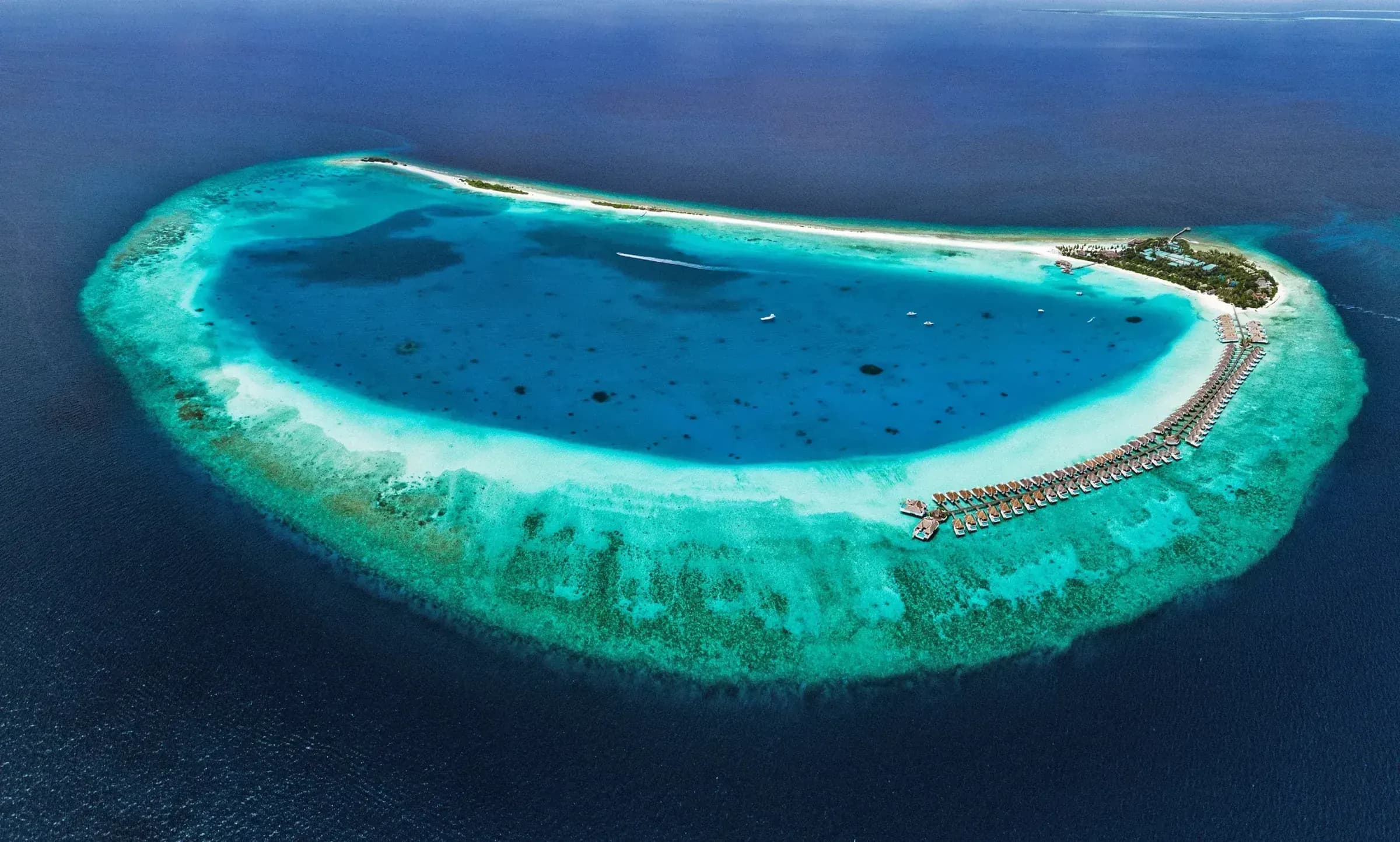 Aerial view of Finolhu Maldives resort island and reef in Baa Atoll