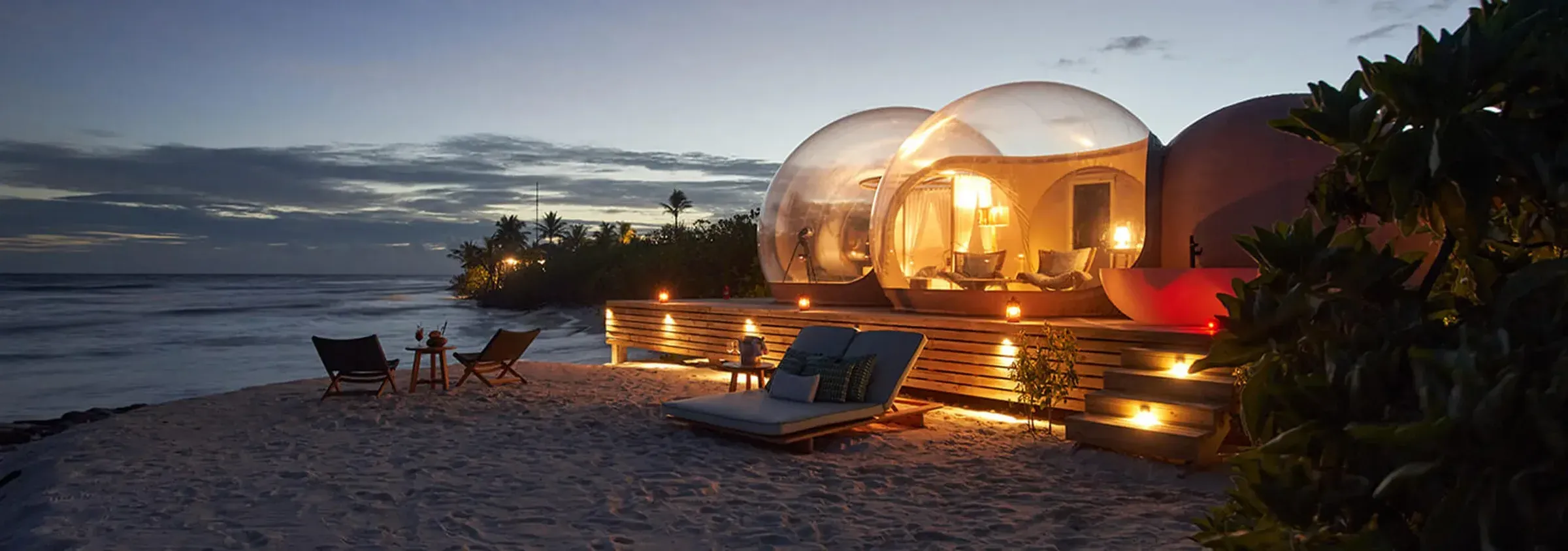 Beach Bubble tent lit up at dusk on the sandbank at Finolhu Maldives