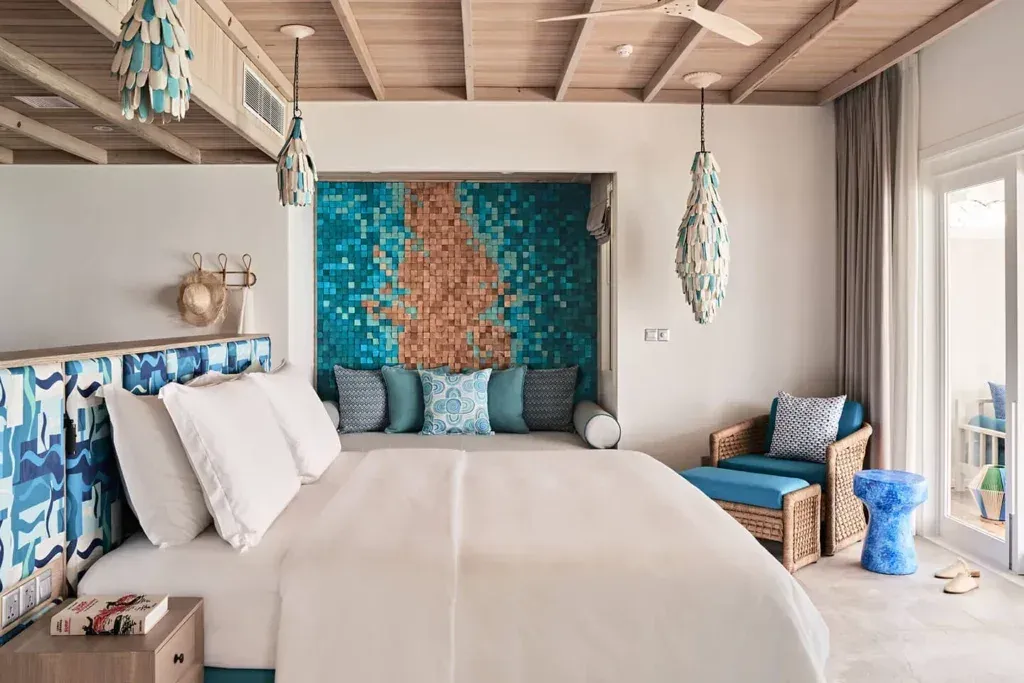 Lagoon Villa bedroom interior at Finolhu Maldives with king bed and turquoise decor accents