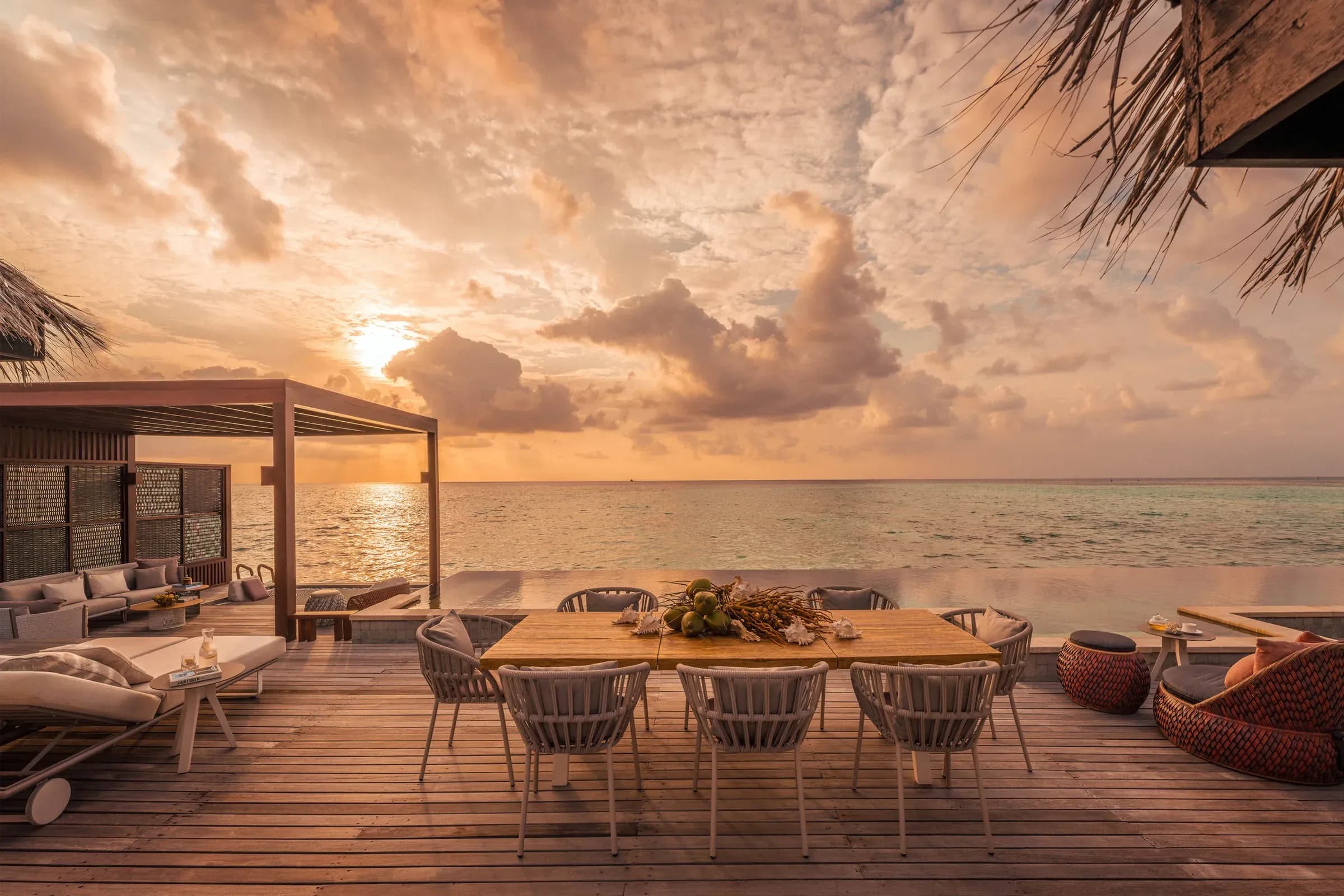Sunset Three-Bedroom Water Suite dining deck at sunset, Four Seasons Resort Maldives at Kuda Huraa