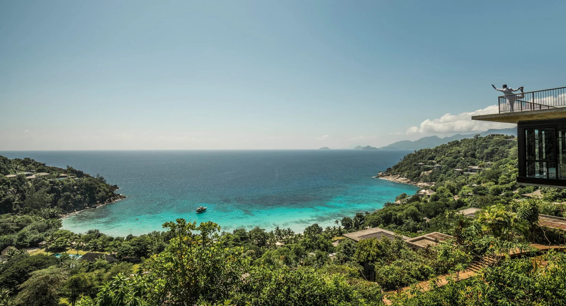 Aerial view of Four Seasons Resort Seychelles' tropical forest hillside and turquoise lagoon at Petite Anse, Mahe