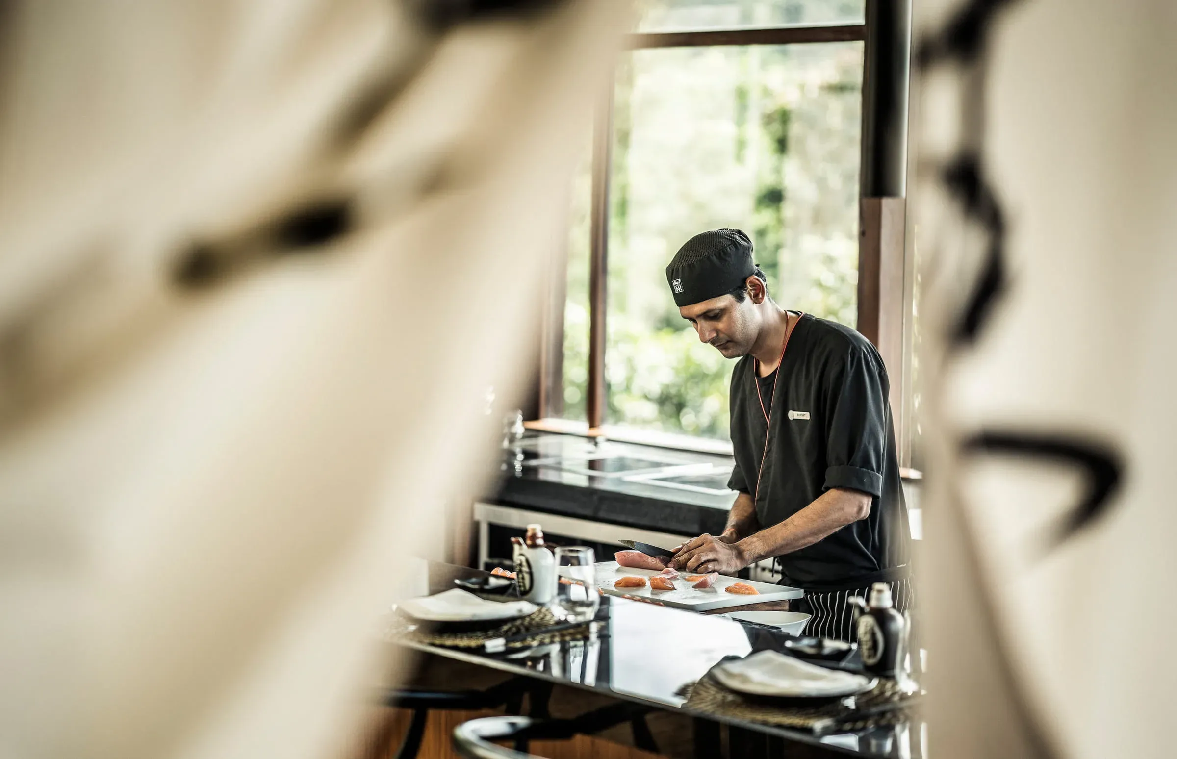 Chef preparing sushi at the counter of KOI, the Japanese restaurant at Four Seasons Resort Seychelles