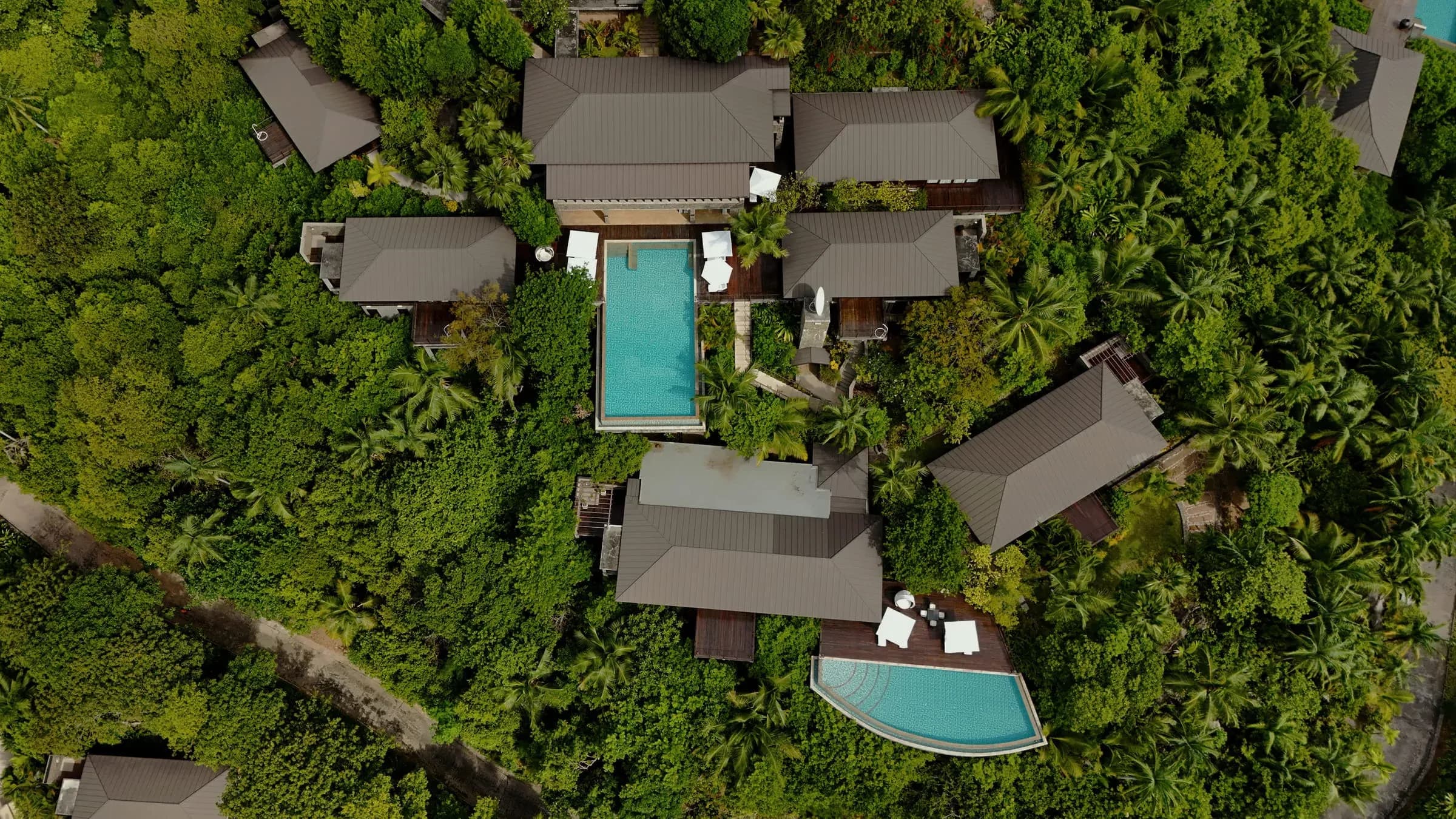 Aerial view of the Eight-Bedroom Residence Villa with two pools set in a jungle landscape at Four Seasons Resort Seychelles