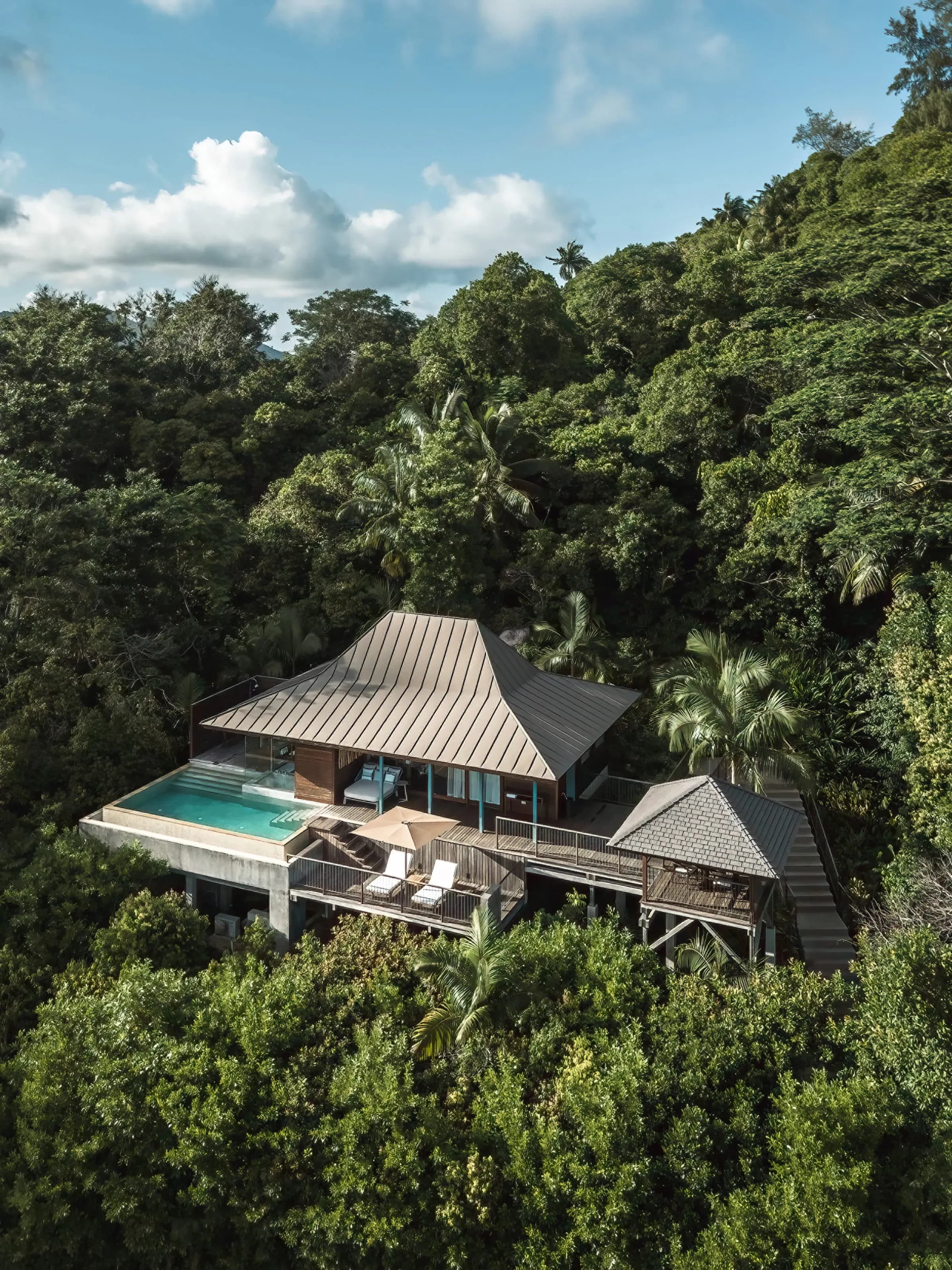 Private villa pool and expansive decking nestled amid tropical foliage at the Ocean-View Villa, Four Seasons Resort Seychelles