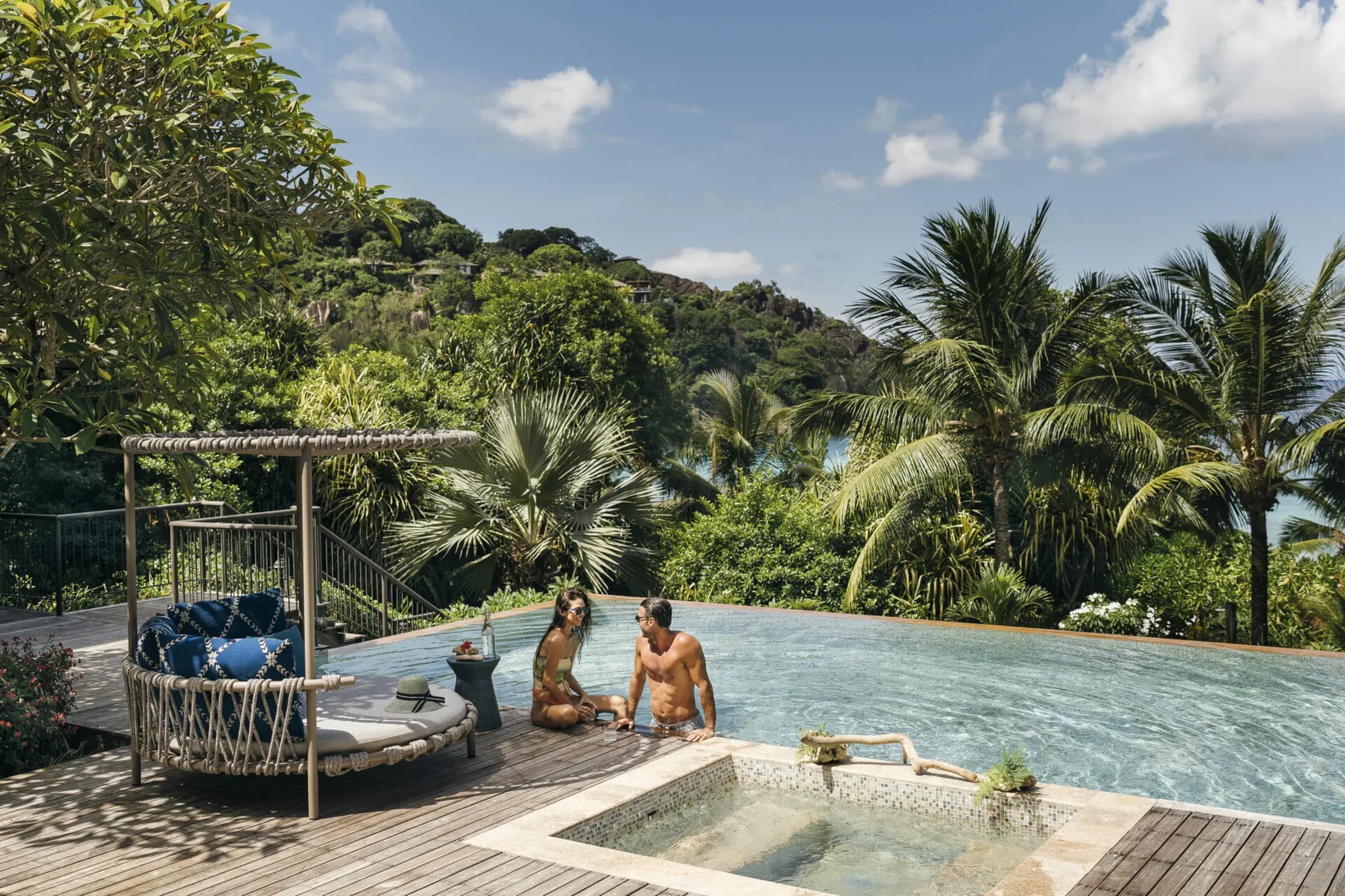 Couple beside the large infinity pool of the Three-Bedroom Presidential Suite at Four Seasons Resort Seychelles