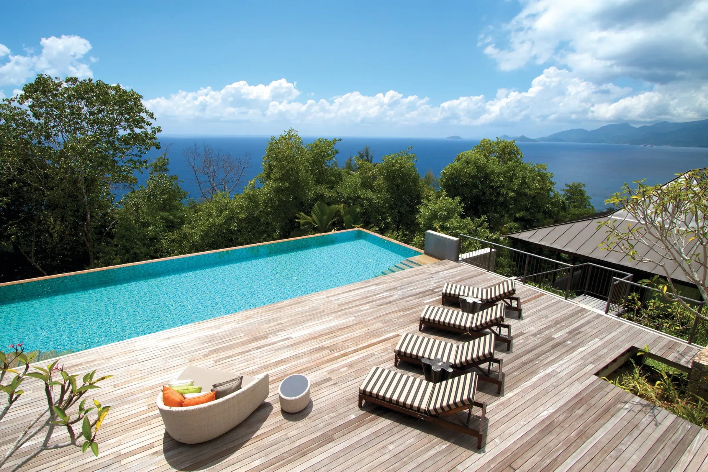 Deck with wood lounge chairs, sofa and plunge pool at the Three-Bedroom Residence Villa, Four Seasons Resort Seychelles