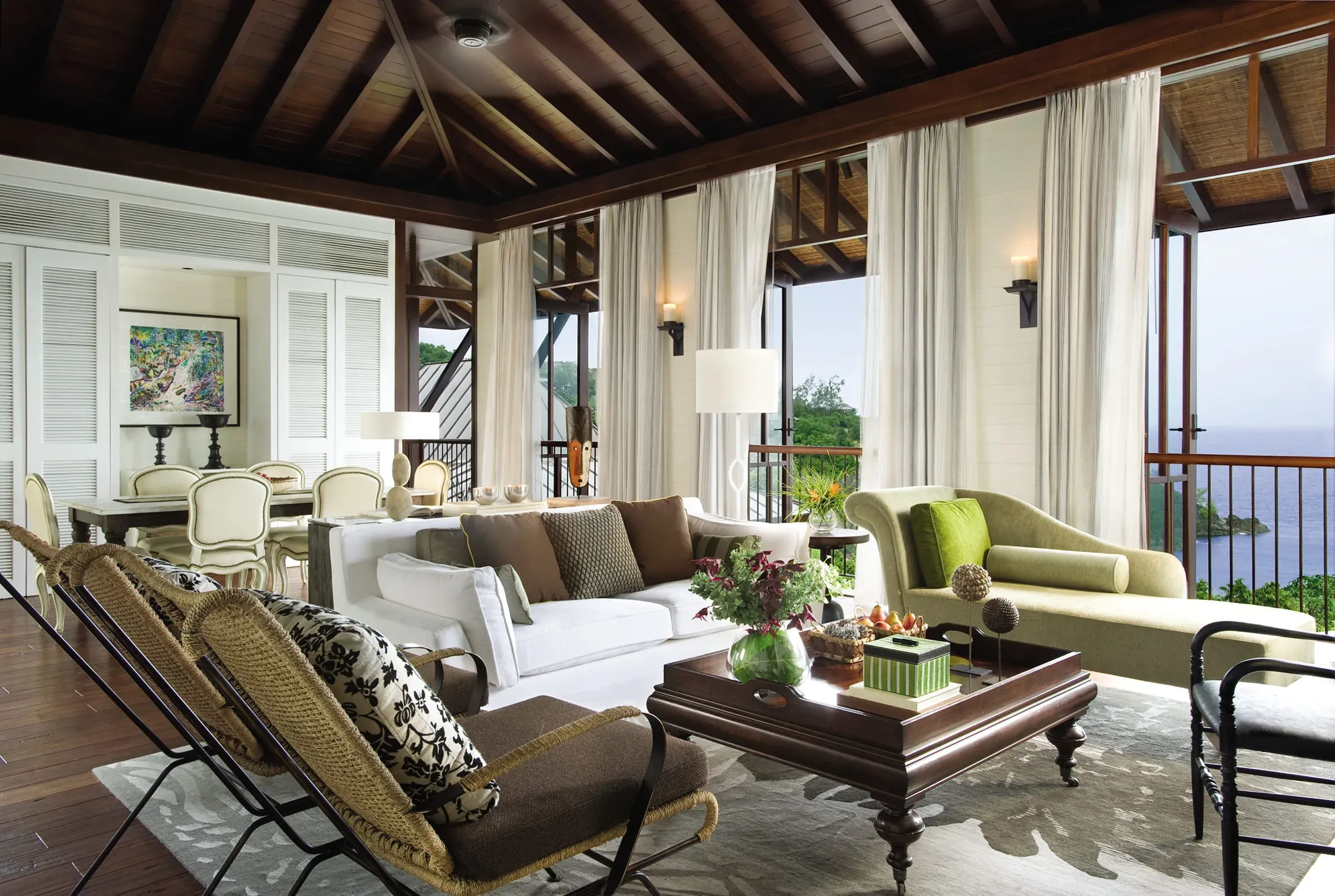 Living room with sofa, chaise lounge and wicker chairs at the Two-Bedroom Ocean-View Suite, Four Seasons Resort Seychelles