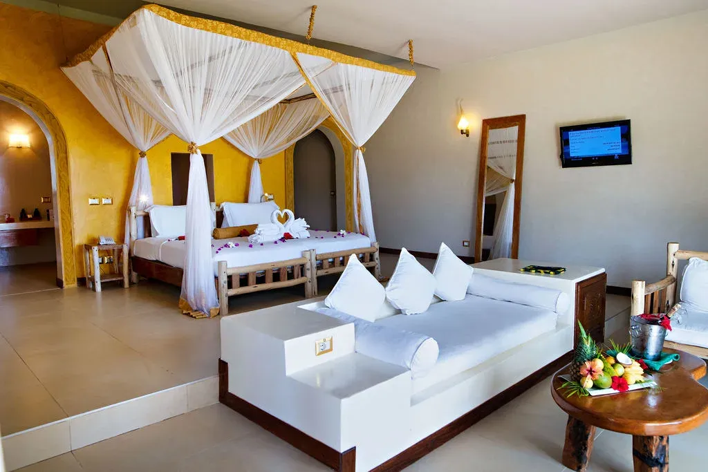 Deluxe Garden View room interior with four-poster canopy bed at Gold Zanzibar