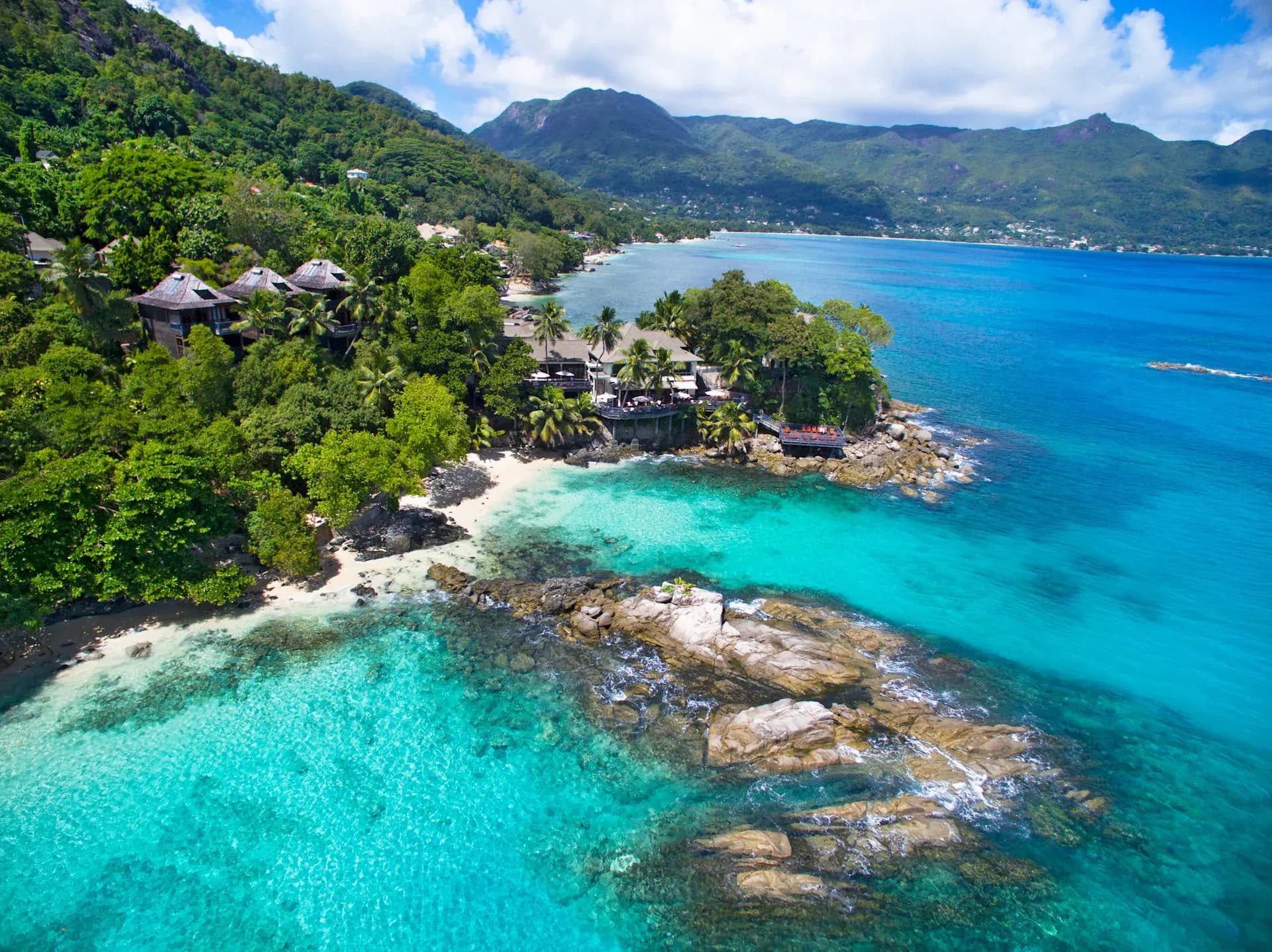 Aerial view of the resort's granite headland and villas above the Indian Ocean at Hilton Seychelles Northolme