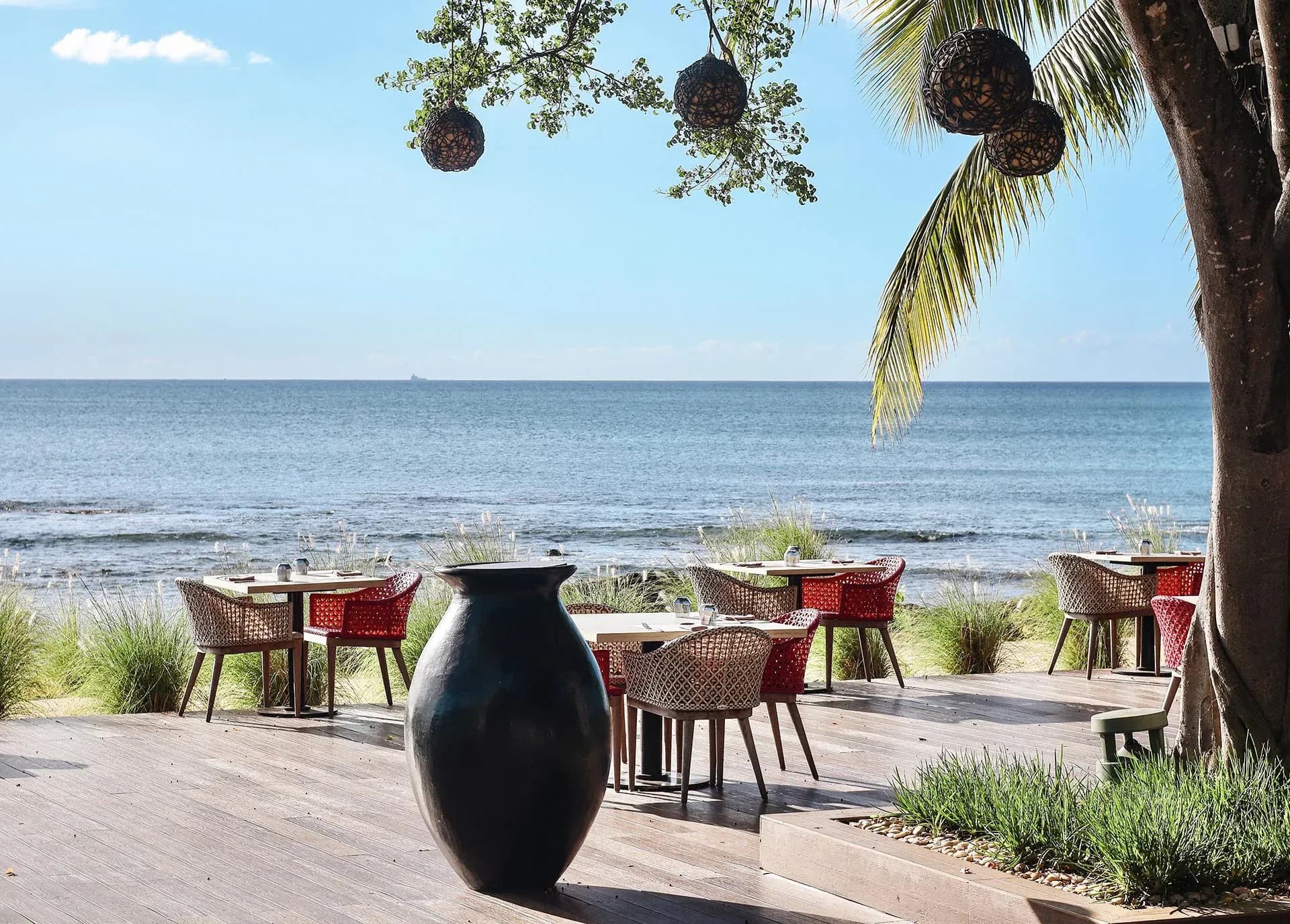 Beachfront dining tables under a tree near Noble House at InterContinental Mauritius Resort Balaclava Fort